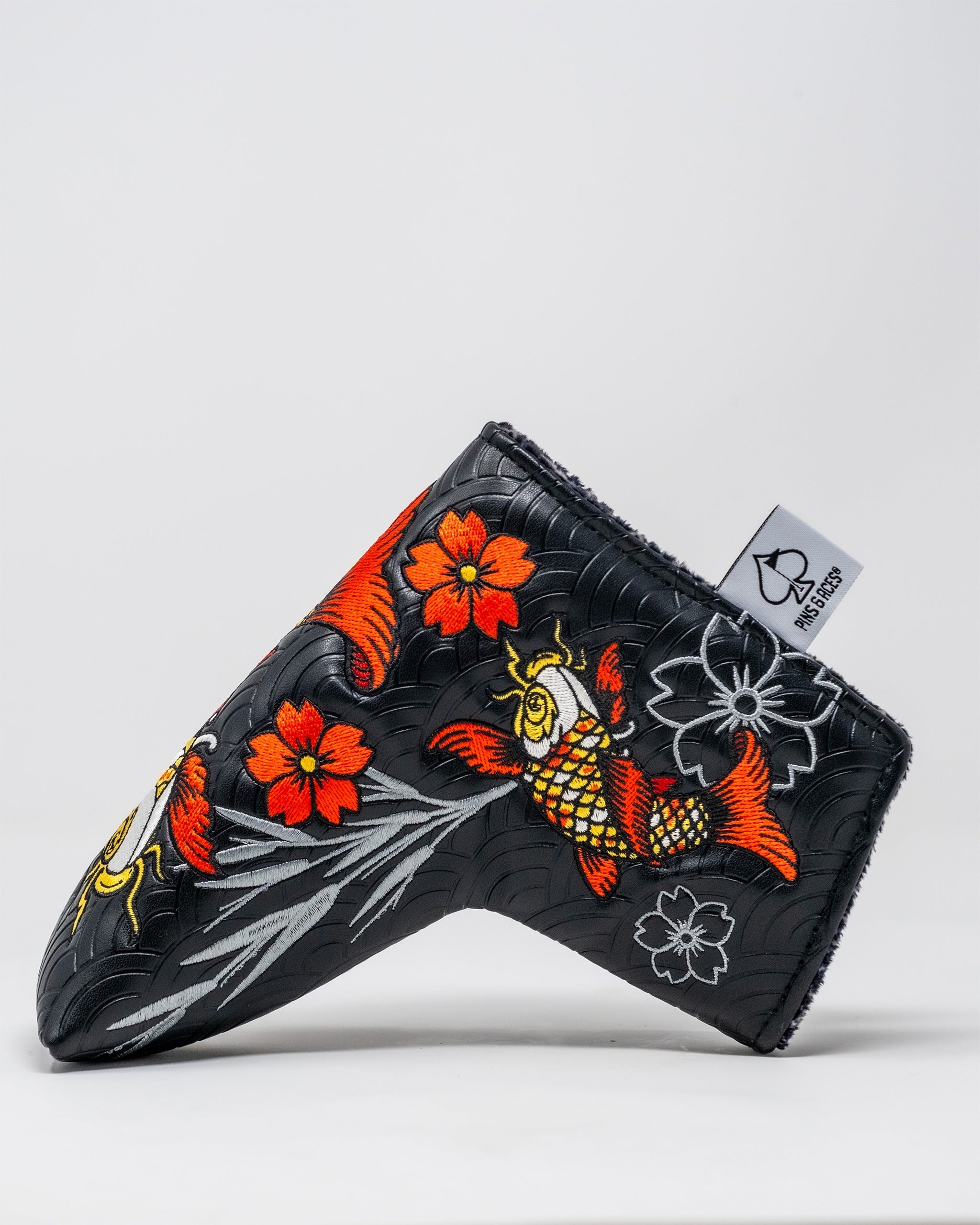 Bold Koi Flow blade putter cover featuring vibrant koi fish and floral designs on a black background for standout golf style.