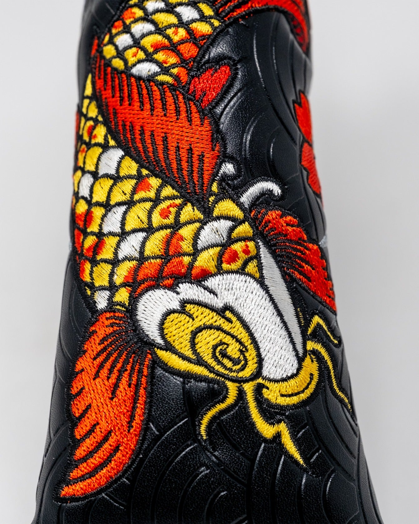 Koi Flow Blade Putter Cover featuring vibrant embroidered koi fish design on a sleek black background.