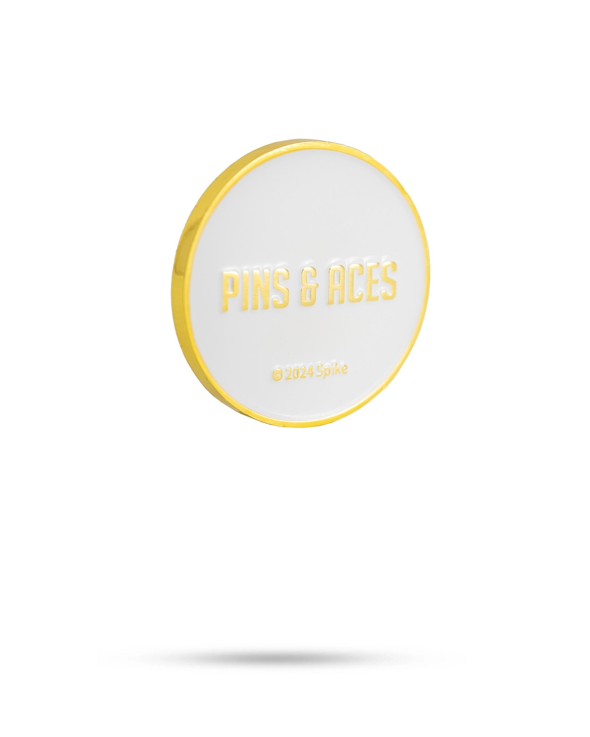Yellowstone ball marker featuring a white surface with gold lettering, showcasing the Pins & Aces brand name.
