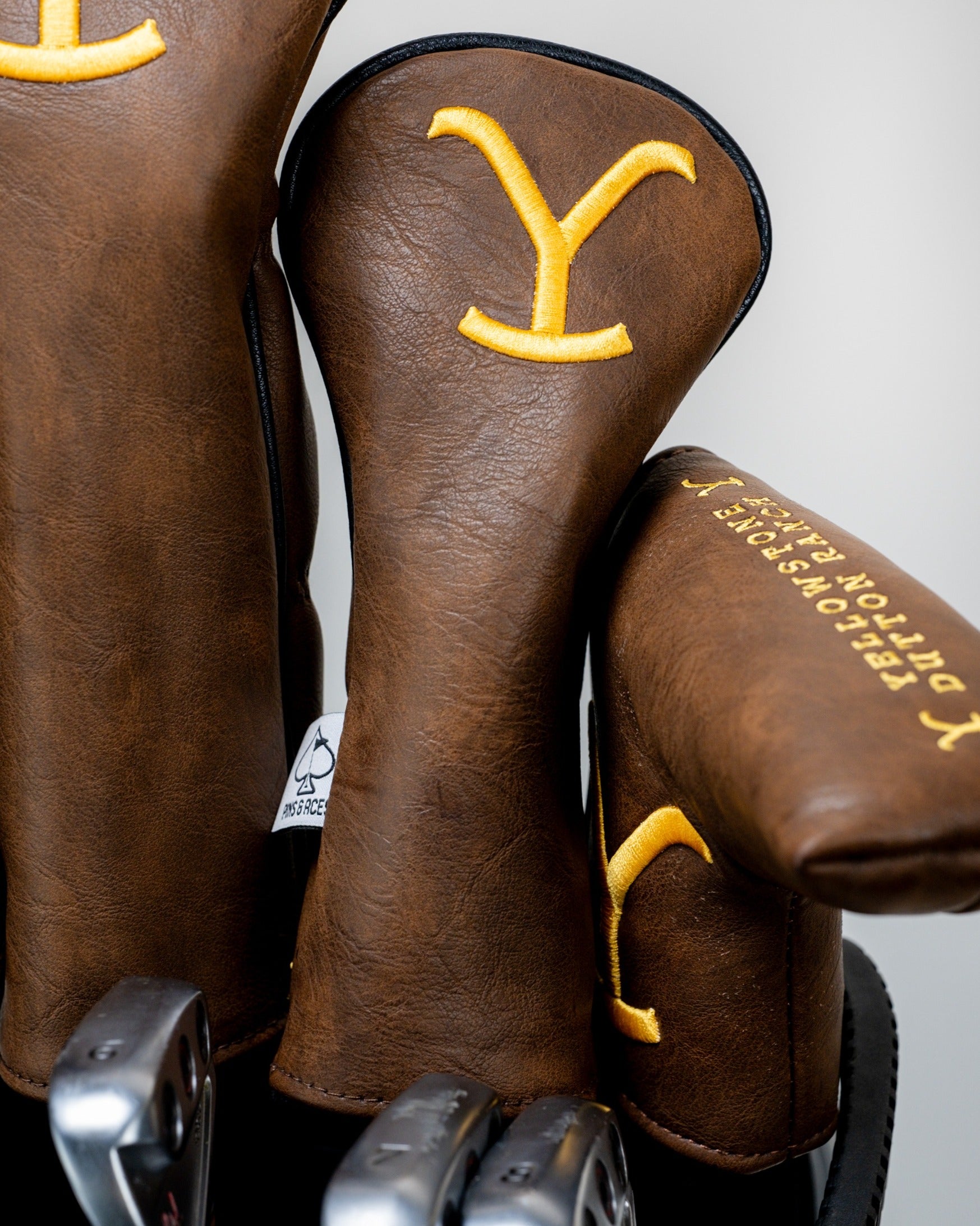 Brown Yellowstone hybrid golf headcovers featuring a bold yellow 'Y' logo, designed for stylish protection on the course.