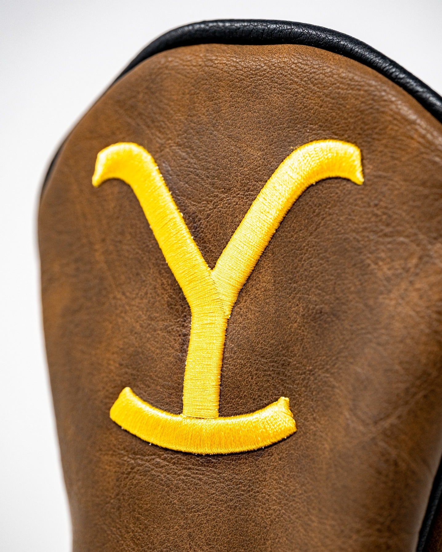 Yellowstone Fairway Cover featuring a bold yellow embroidered "Y" on a rich brown leather background.