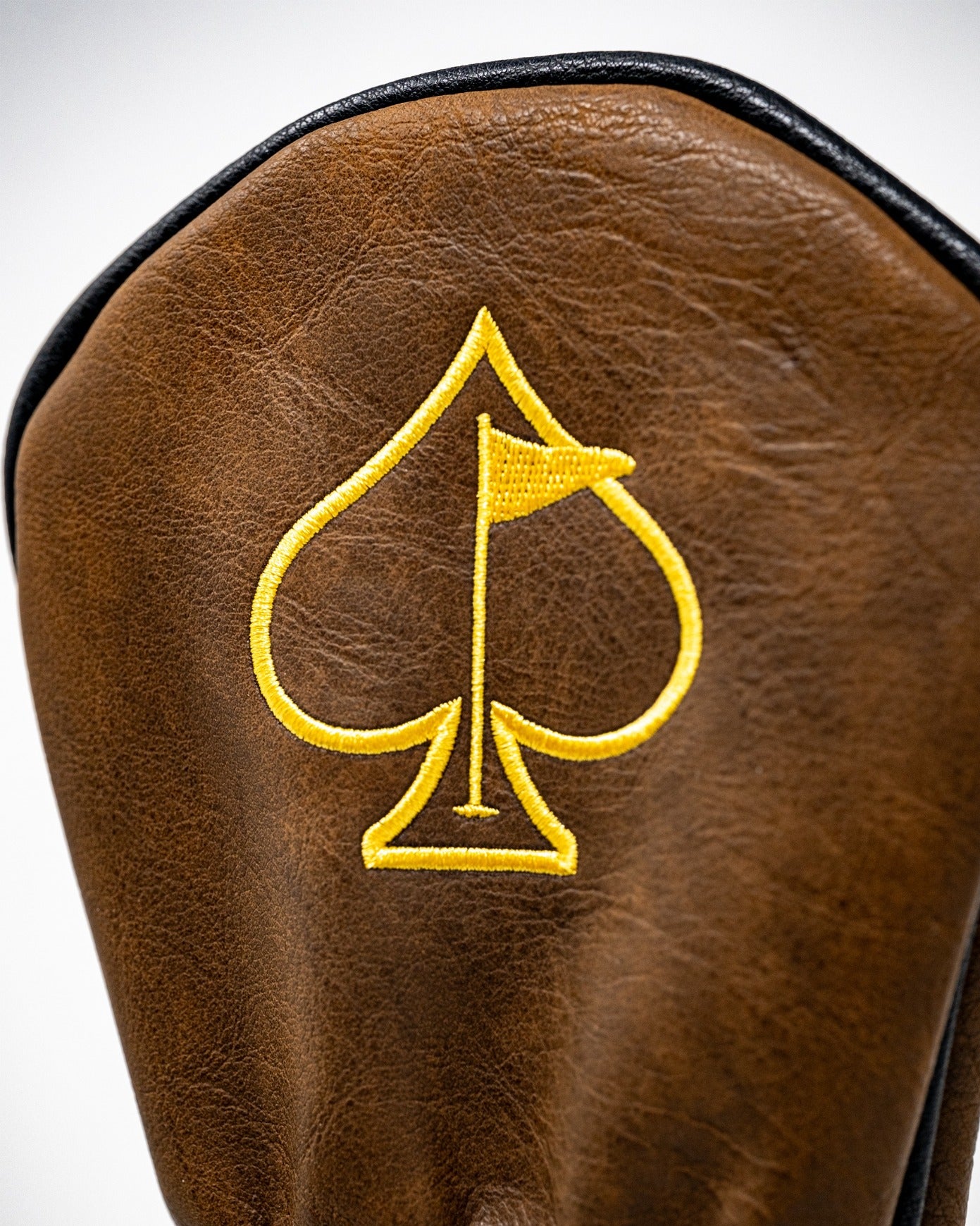 Yellowstone Fairway Cover featuring a brown leather design with a yellow spade and flag emblem, perfect for stylish golfers.