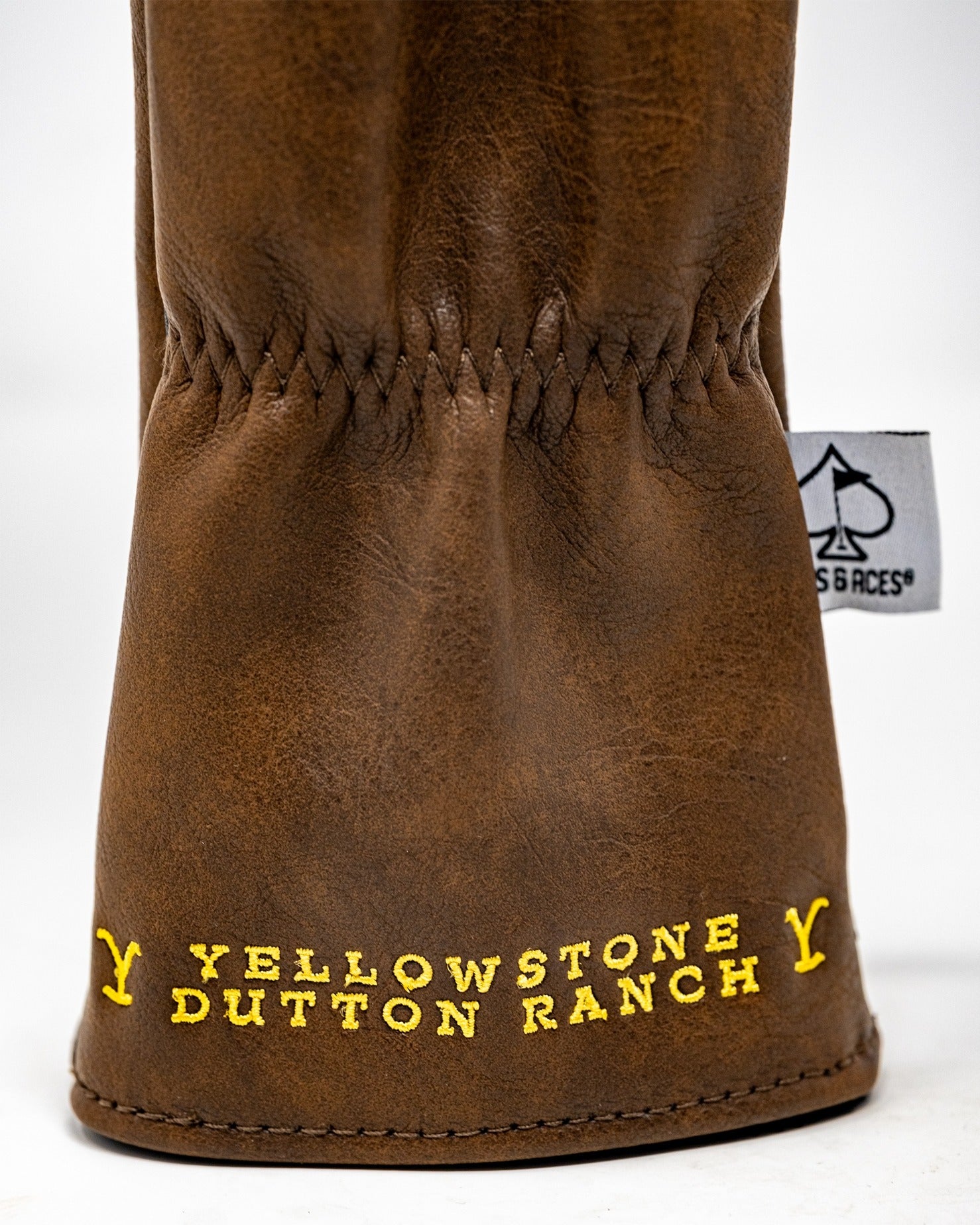Brown leather fairway cover featuring "Yellowstone Dutton Ranch" in bold yellow lettering. Ideal for stylish golfers.