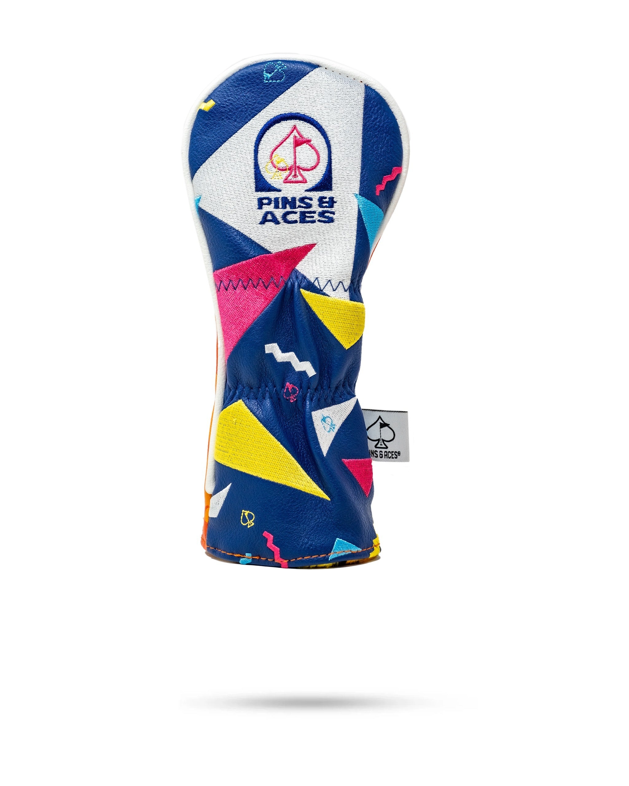 Bold golf headcover featuring a vibrant geometric design in blue, pink, and yellow with the Pins and Aces logo.