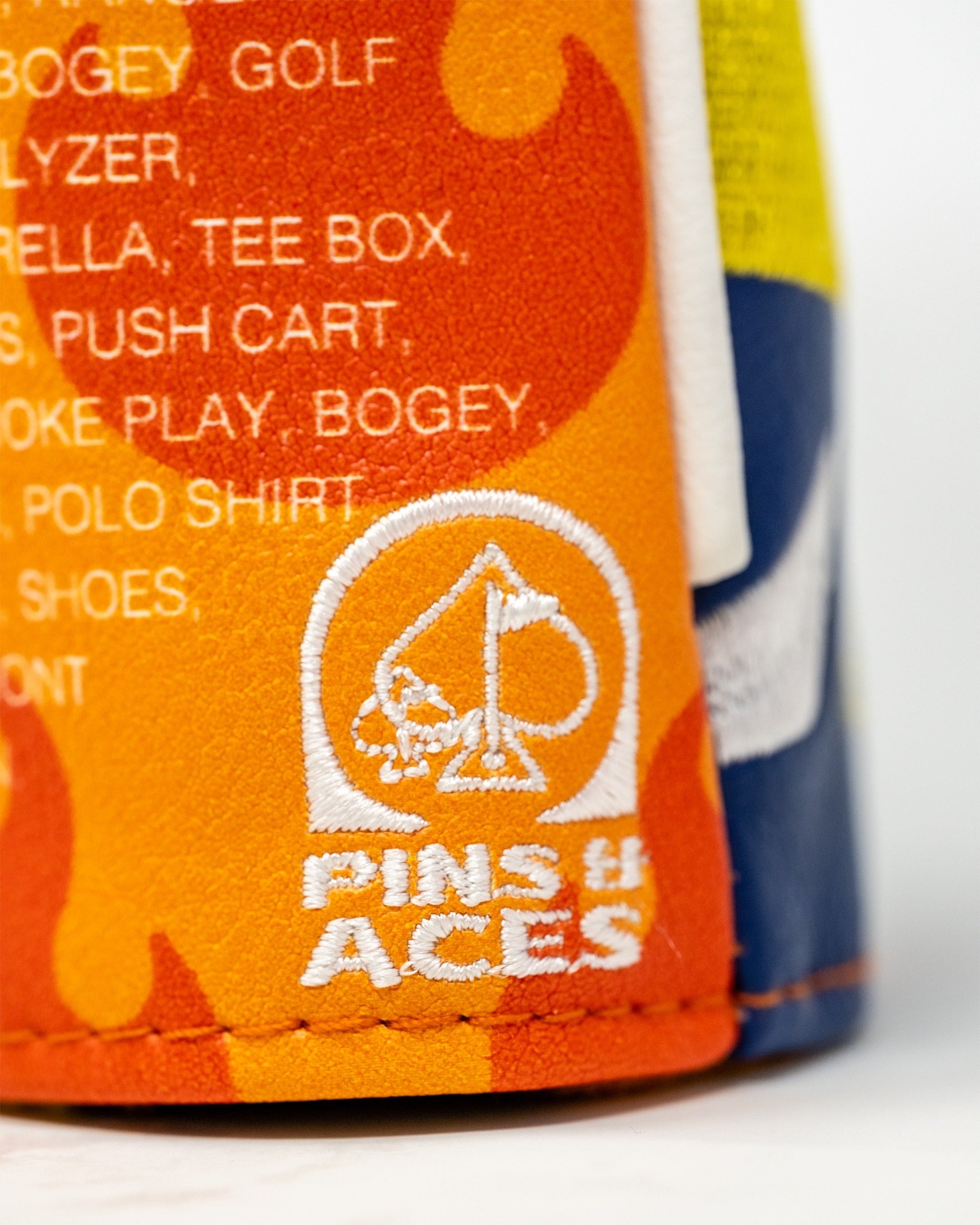 Bold hybrid golf cover featuring a vibrant orange and blue design with the Pins and Aces logo prominently displayed.