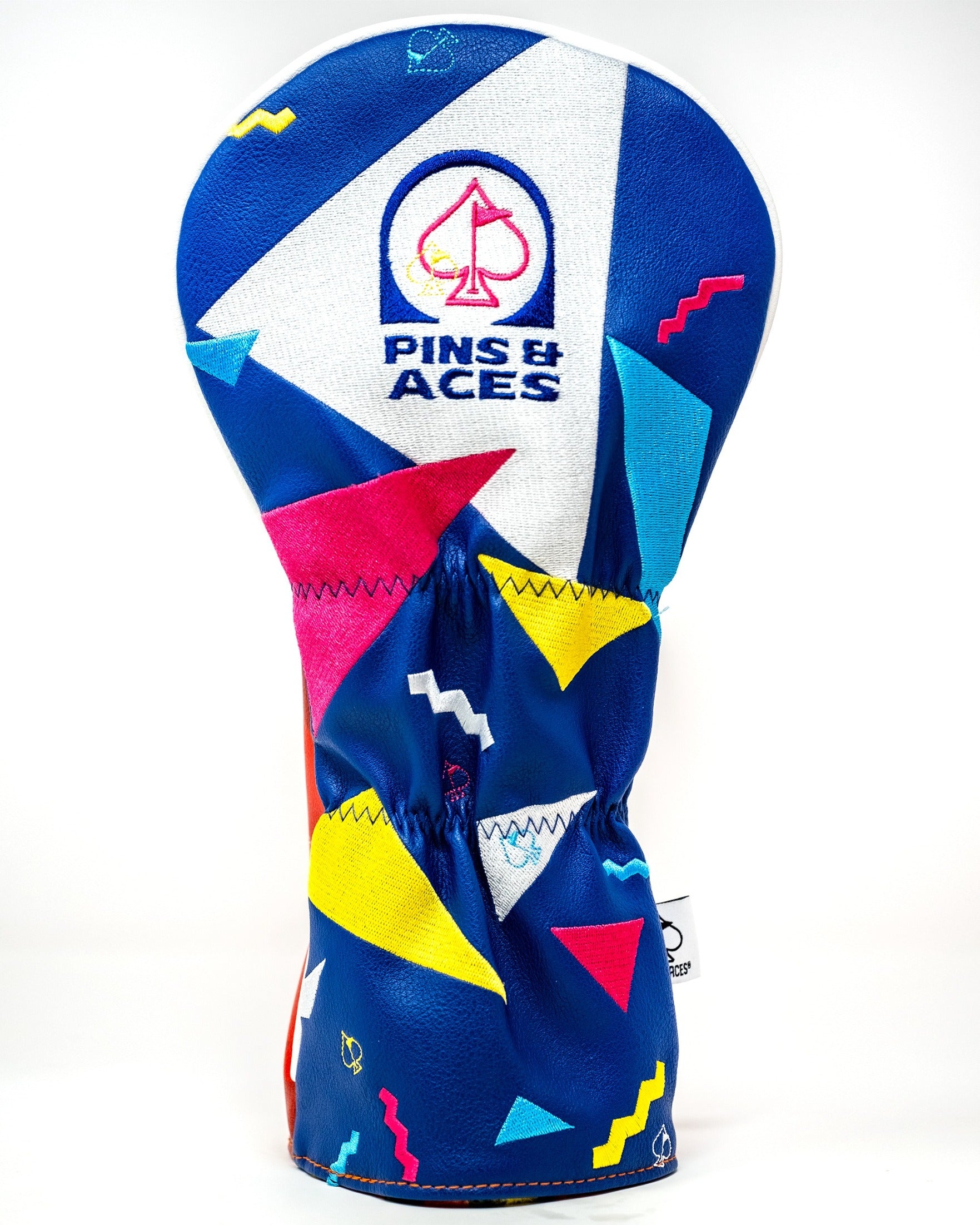 Bold blue driver cover featuring colorful geometric patterns and the Pins & Aces logo, perfect for stylish golfers.