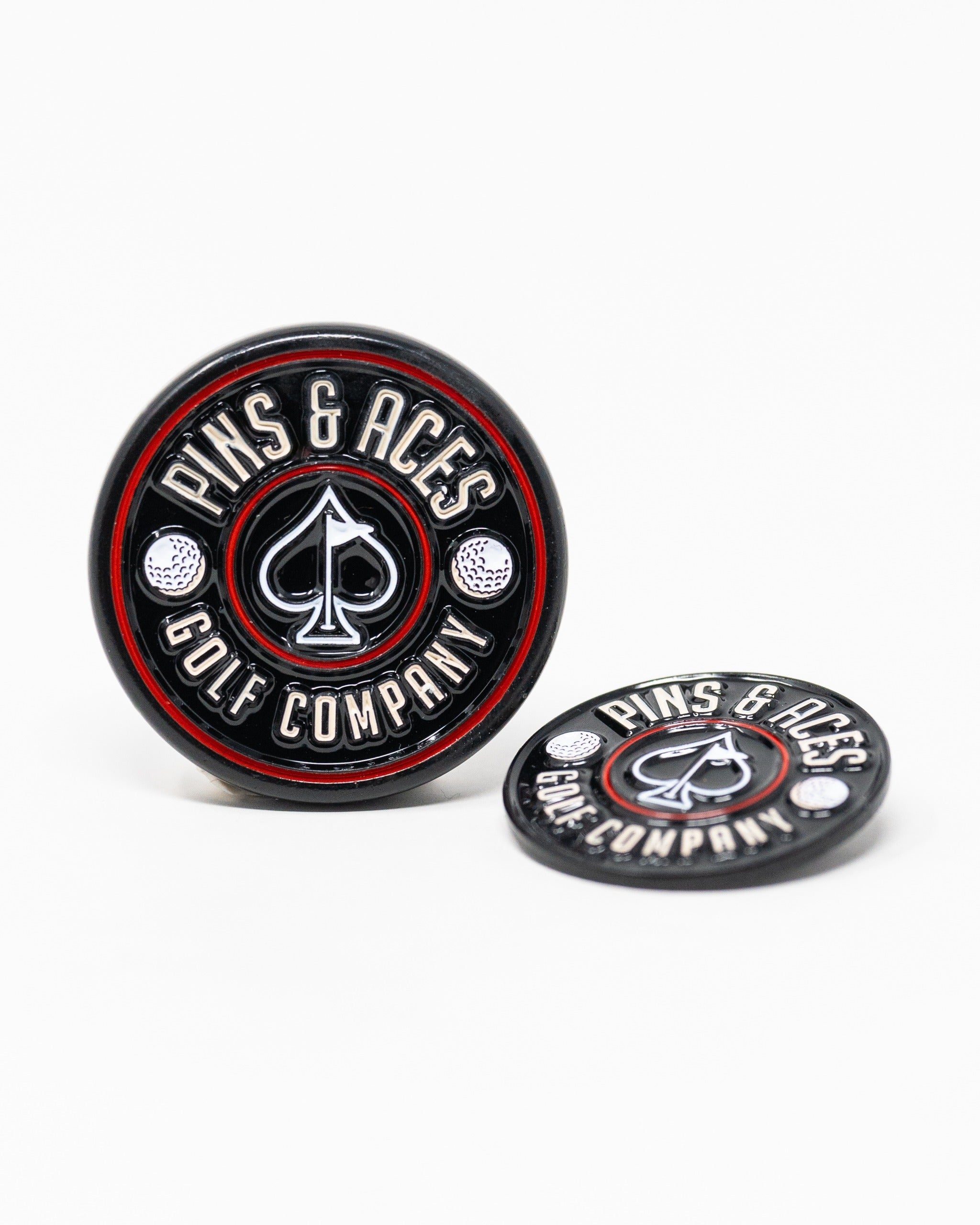Black Pop Out Medallion Ball Marker featuring a spade design and "Pins & Aces Golf Company" branding for stylish golfing.