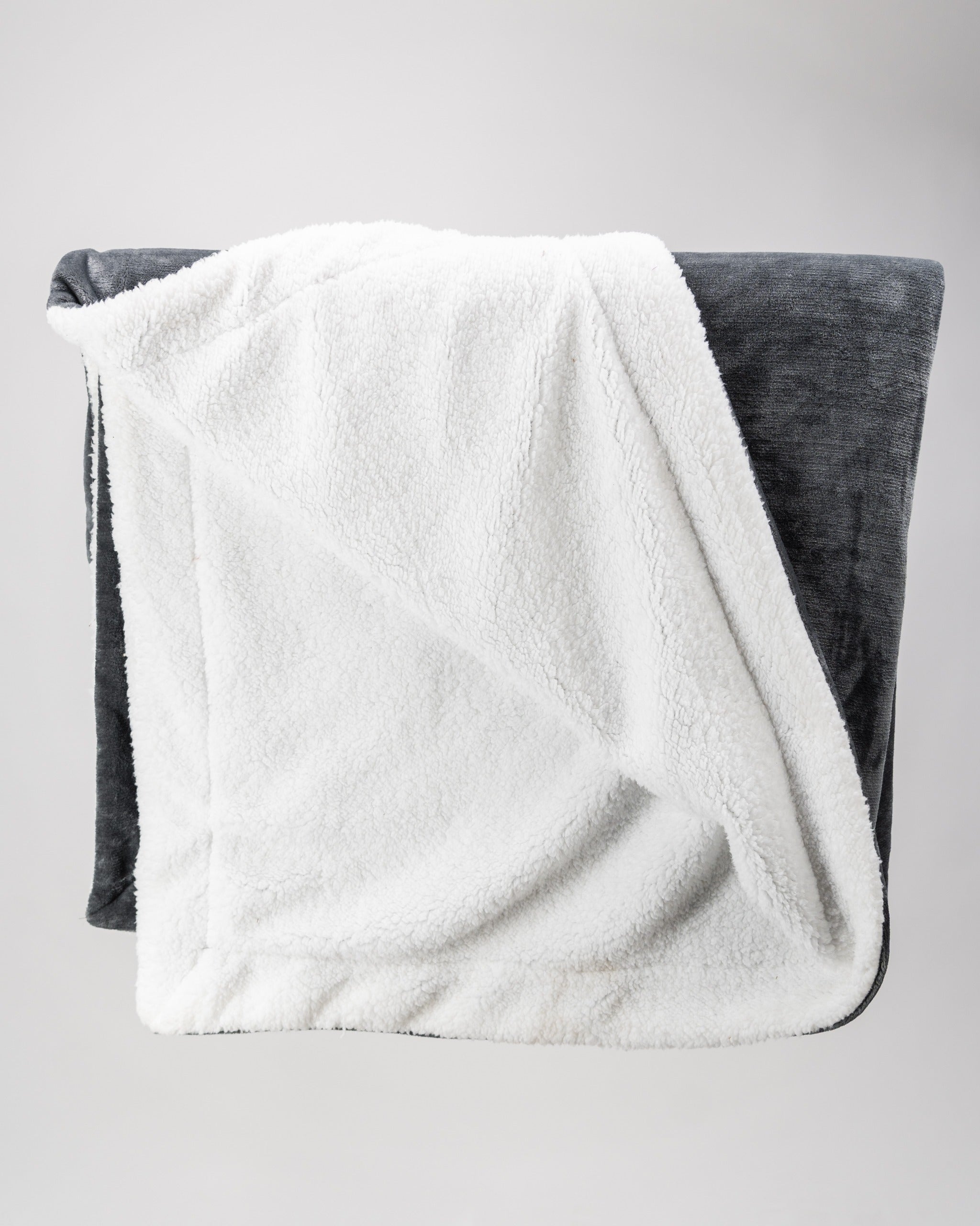 Cozy dark gray Bogey Blanket featuring a soft white fleece lining, perfect for warmth on and off the golf course.