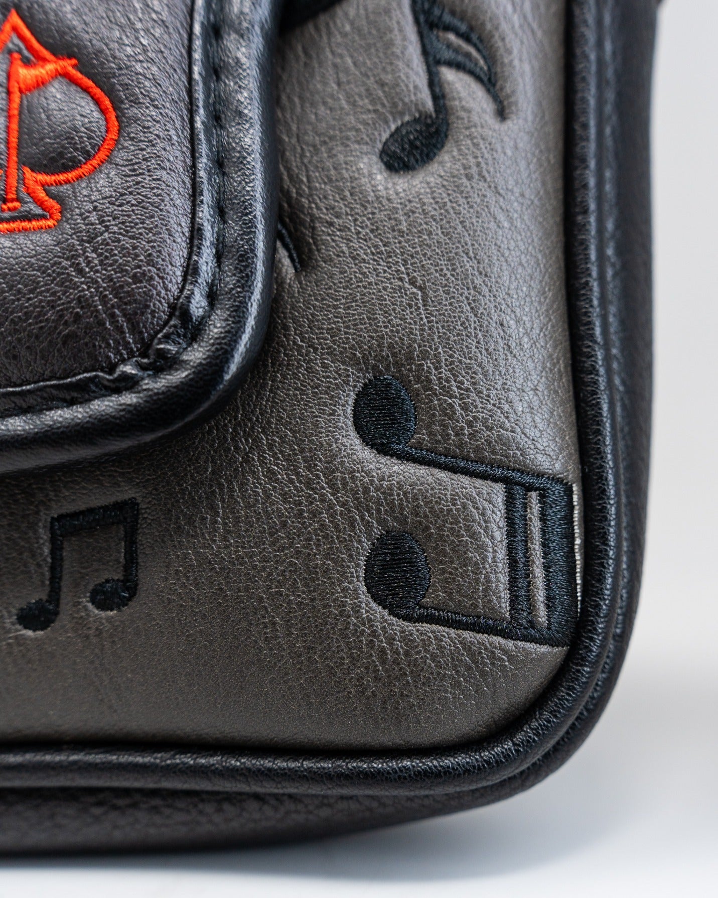 Black mallet putter cover featuring musical notes and an embroidered logo, perfect for stylish golfers.