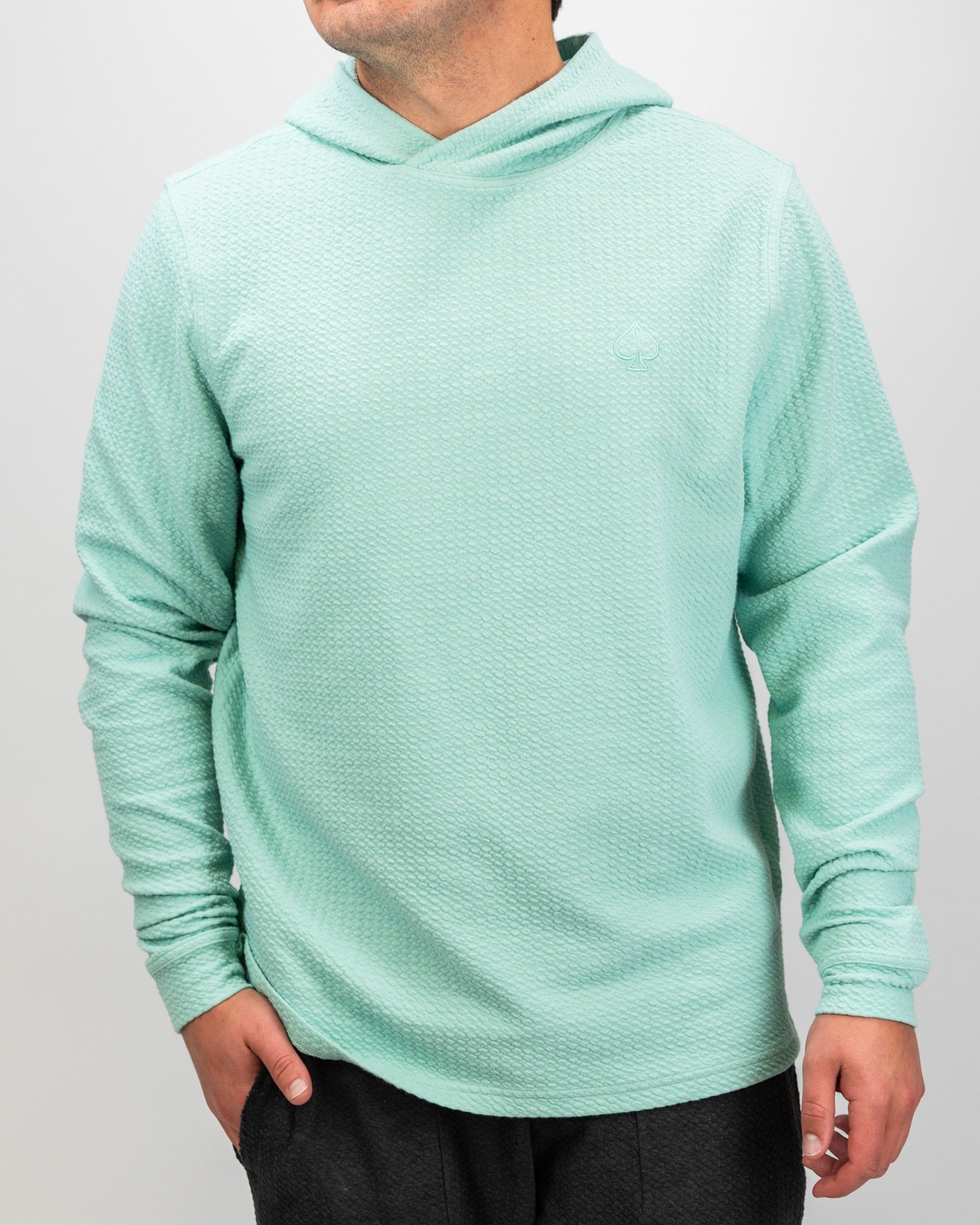 Bright mint waffle knit hoodie for golfers, featuring a relaxed fit and stylish design for comfort on and off the course.