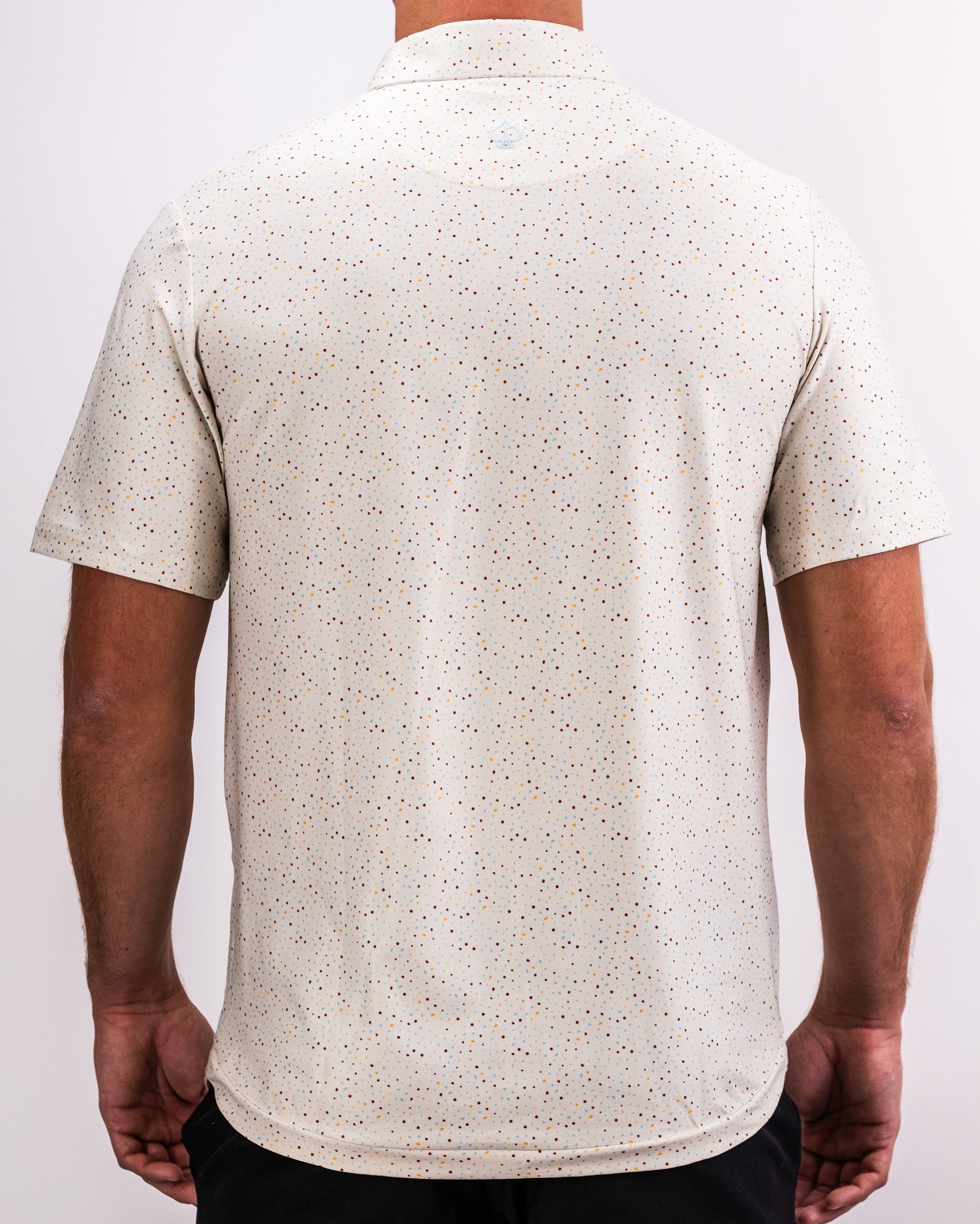 Men's Player Preferred Polo in Terrazzo pattern, featuring a stylish design with a light background and colorful speckles.