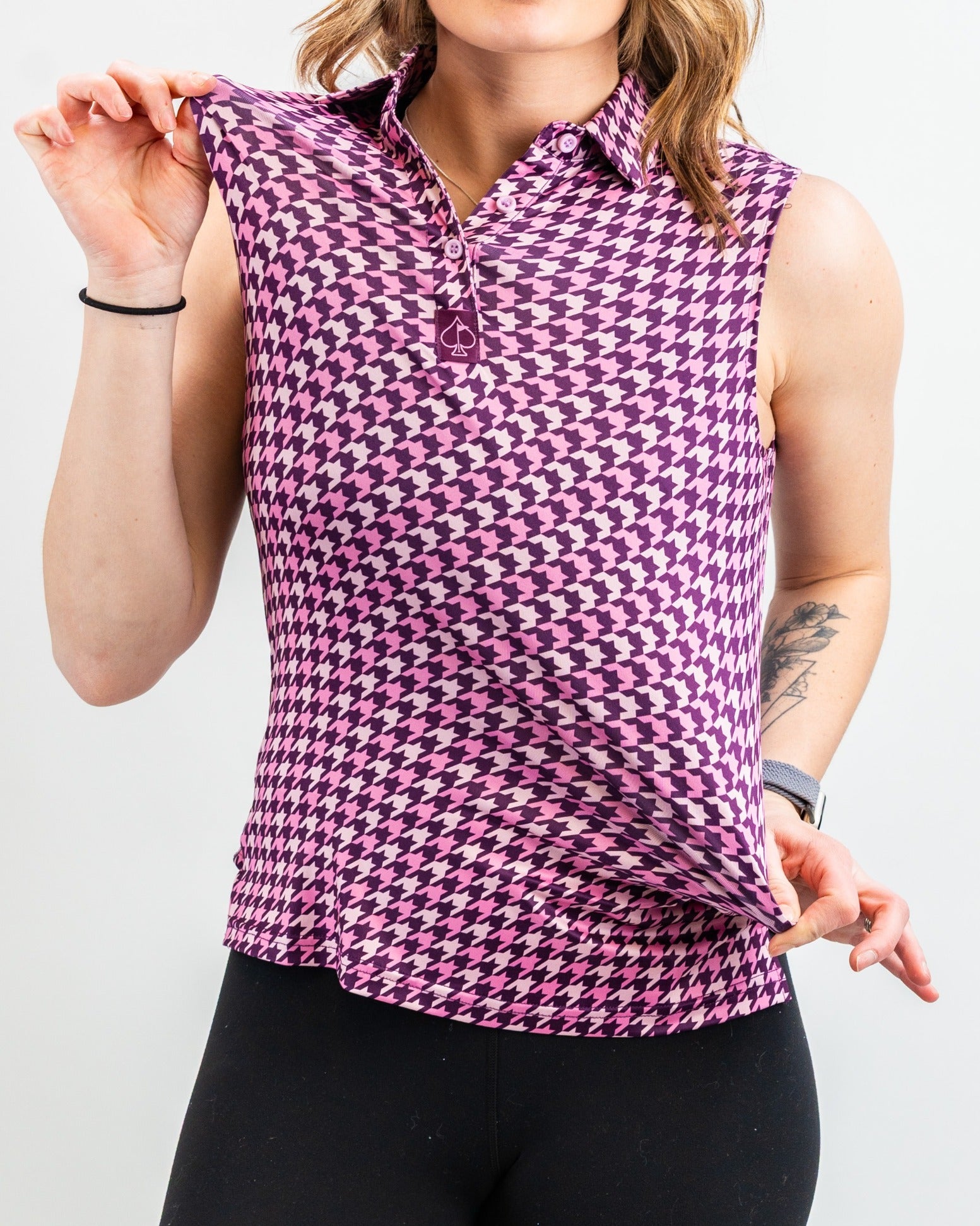 Women's sleeveless houndstooth golf top in raspberry, featuring a collared neckline and a flattering fit for stylish play.