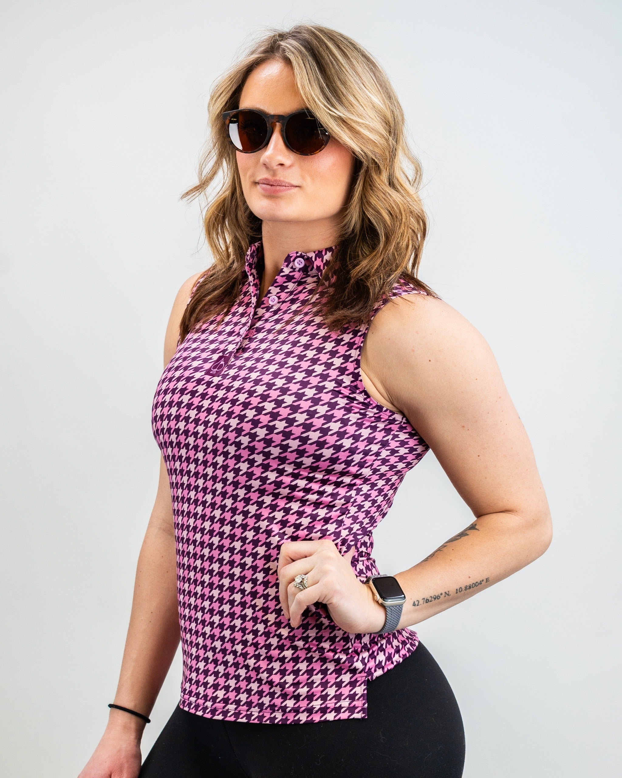Women's houndstooth raspberry golf polo featuring a stylish collar and sleeveless design, perfect for a bold look on the course.
