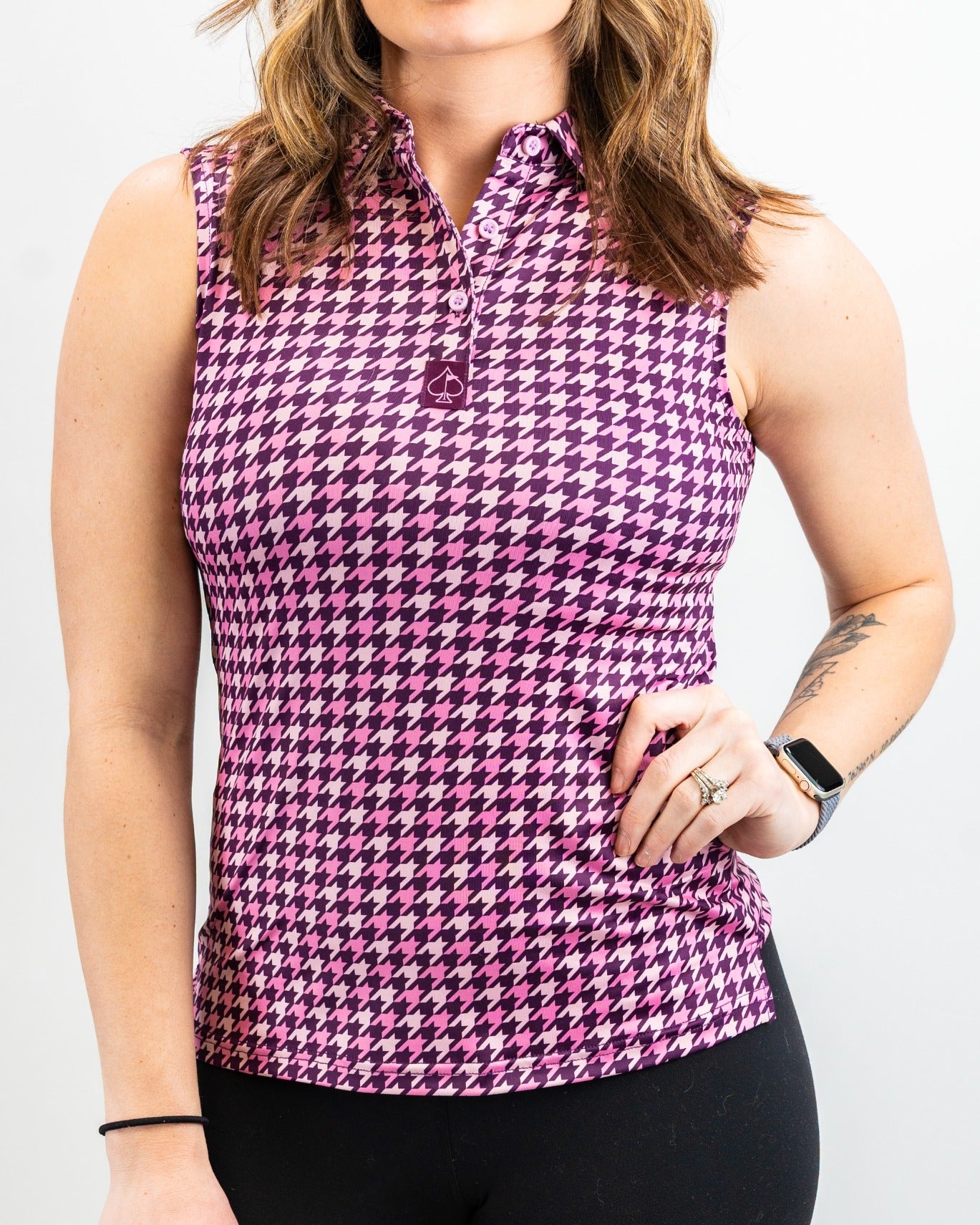 Women's sleeveless houndstooth golf top in raspberry, featuring a collar and a stylish, fitted design for a bold look on the course.