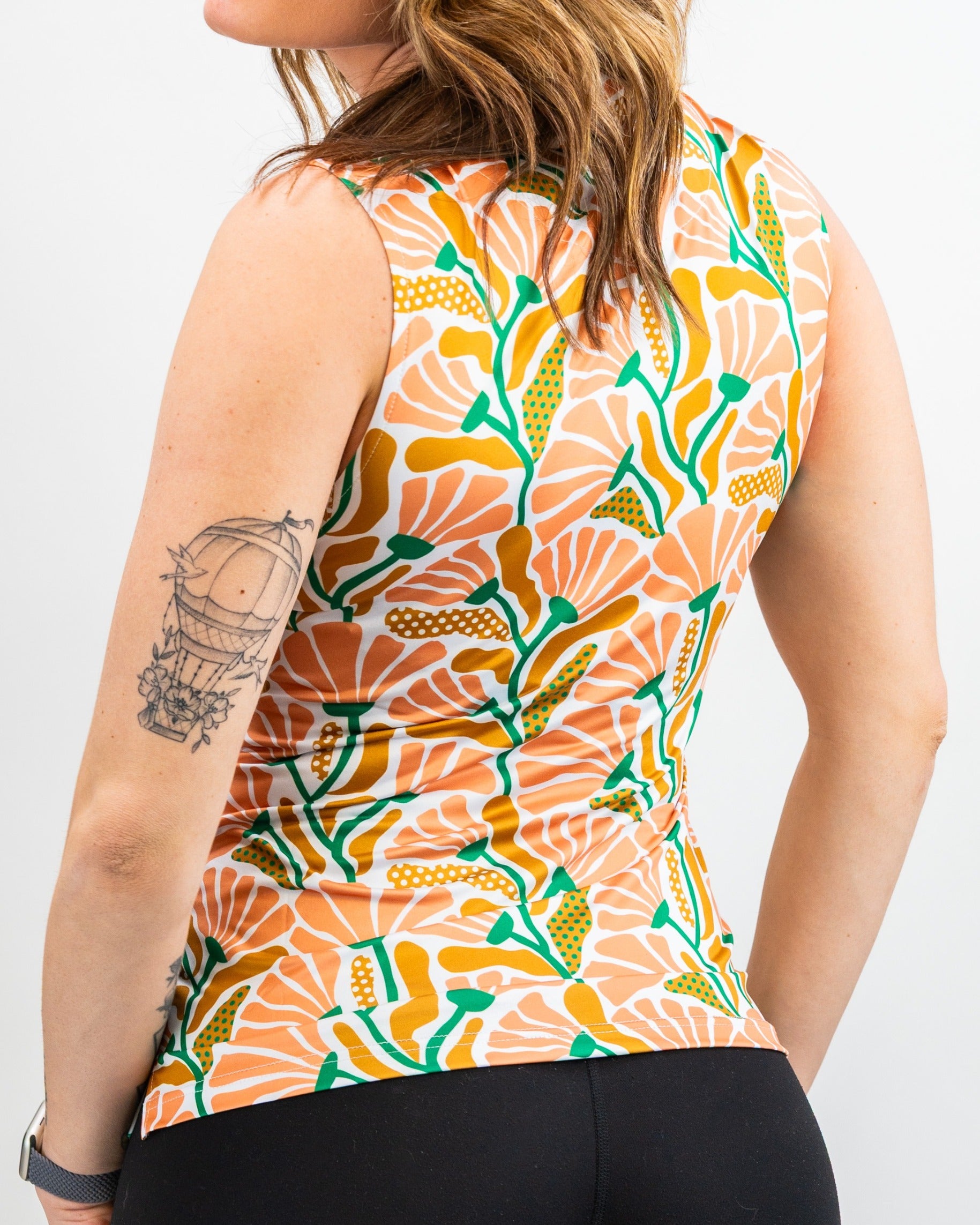 Back view of a woman wearing a colorful floral tank top, showcasing a vibrant garden party design.