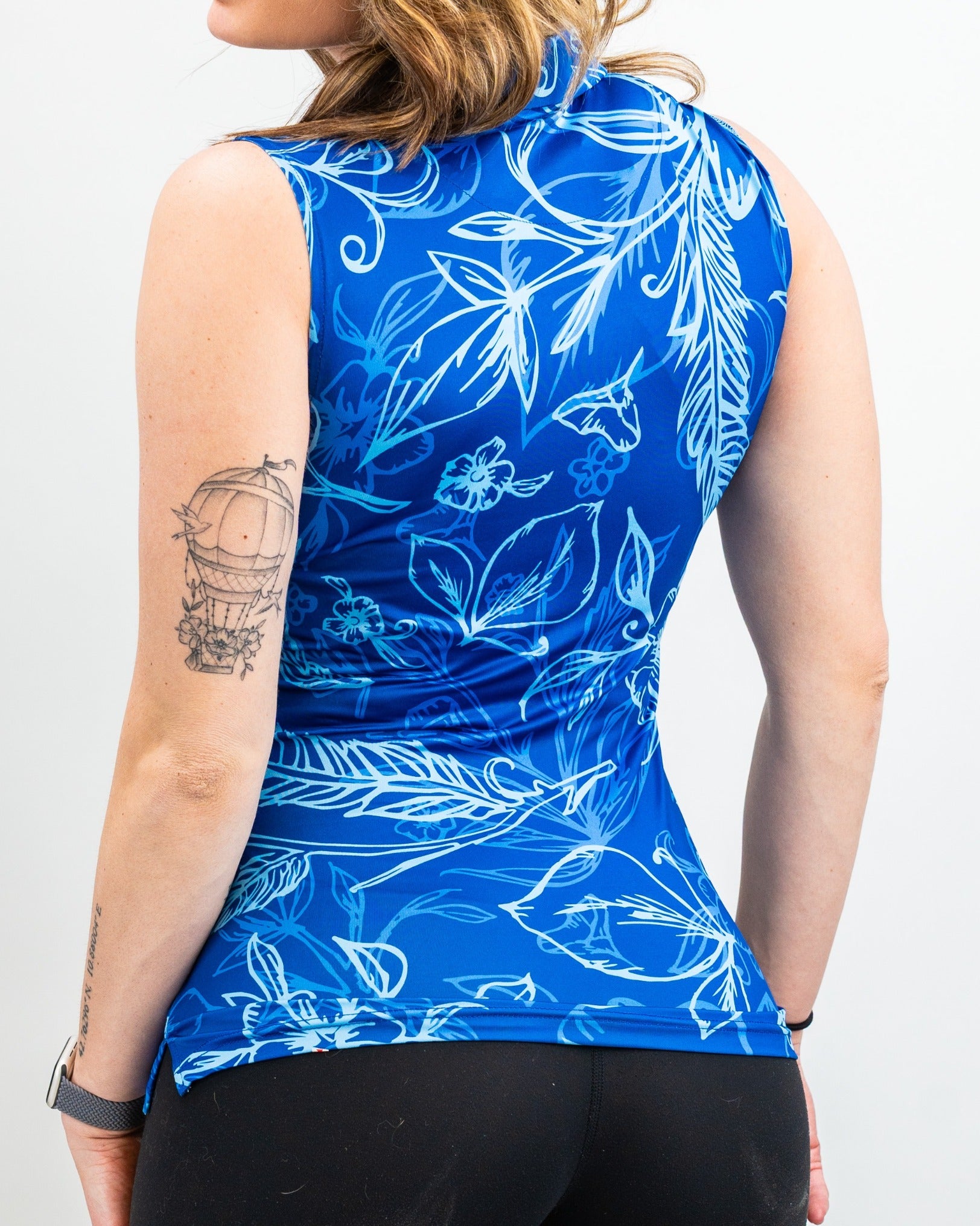 Women's Cabo Ocean sleeveless golf top featuring a vibrant blue floral design, perfect for stylish performance on the course.