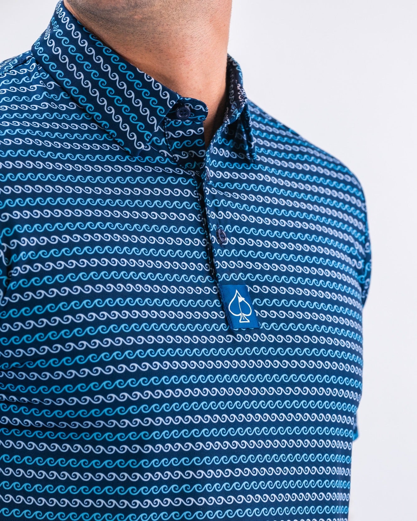 Men's golf polo shirt featuring a wave pattern in blue tones, designed for a stylish and bold look on the course.
