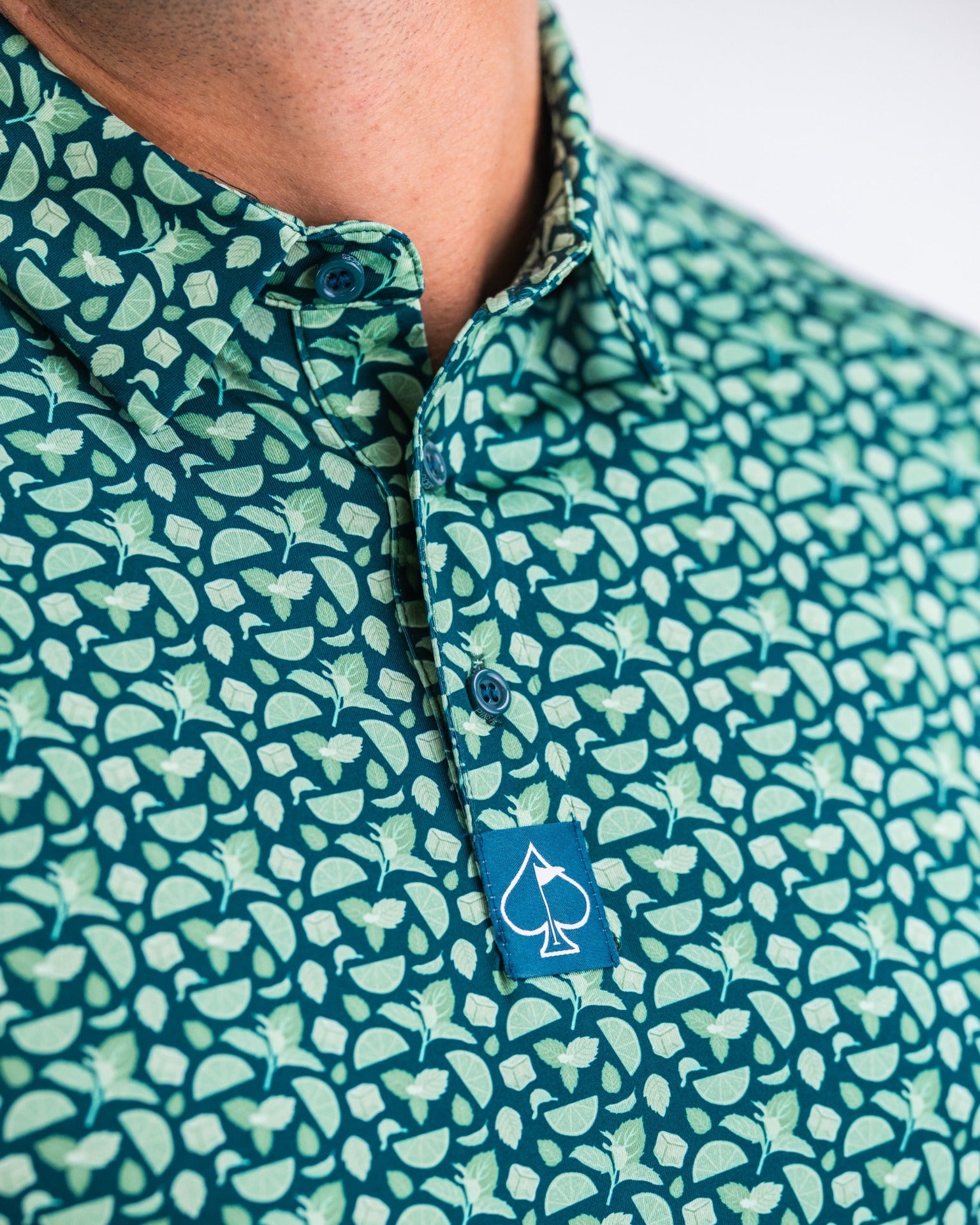 Mint Julep golf shirt featuring a vibrant green pattern of mint leaves and lime slices, perfect for stylish golfers.