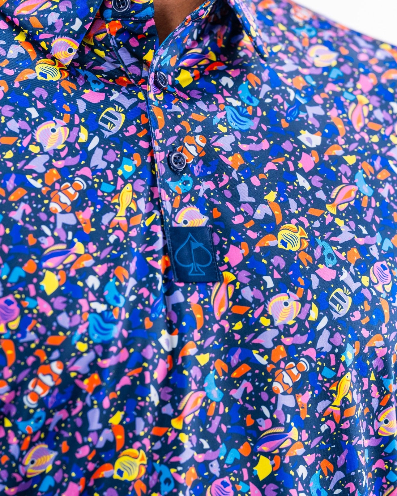 Vibrant tropical shirt featuring a colorful fish and coral pattern, perfect for making a bold statement on the golf course.