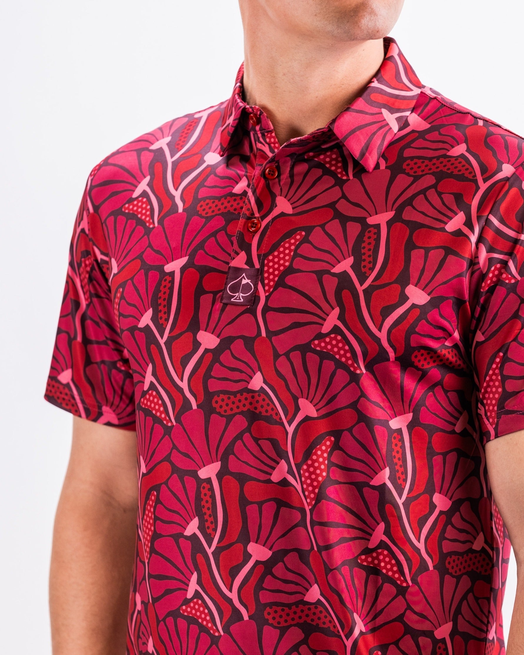 Bold crimson golf polo featuring a vibrant floral pattern, perfect for golfers wanting to make a statement on the course.