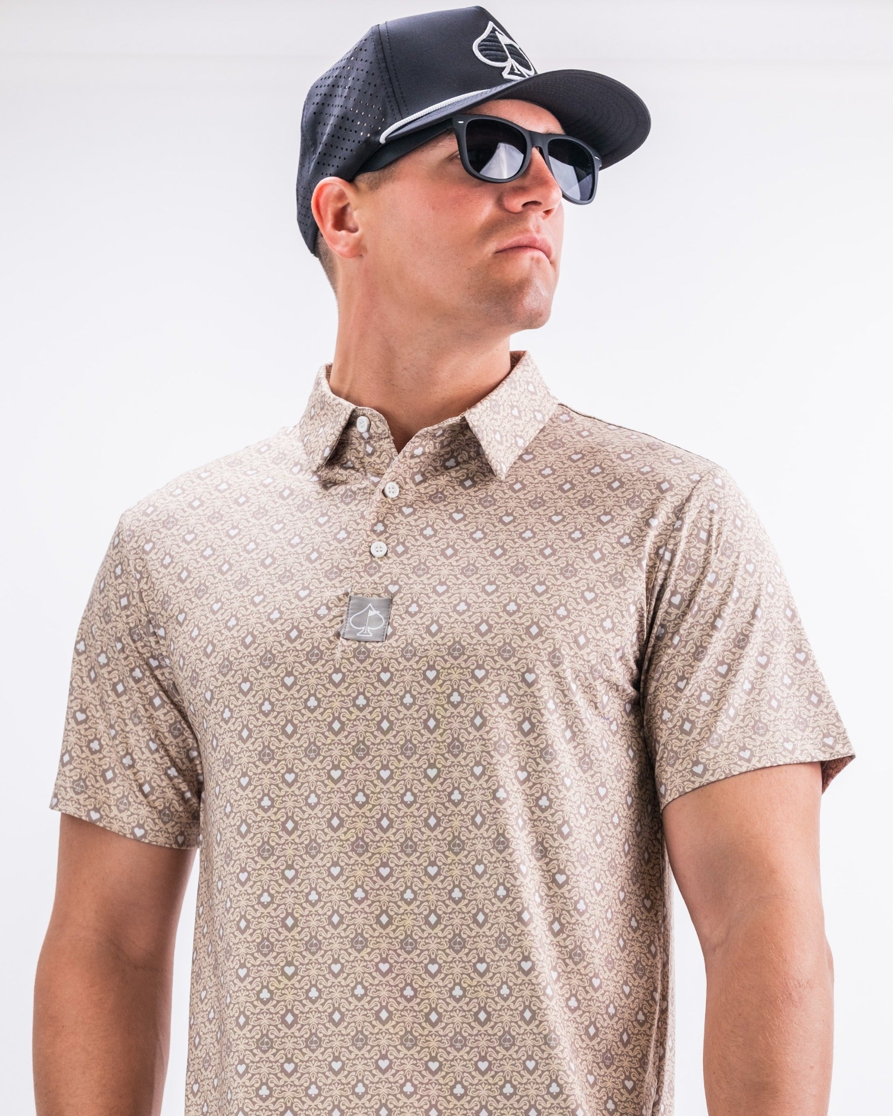 Stylish golfer wearing a patterned polo shirt and cap, showcasing bold golf apparel for a standout look on the course.