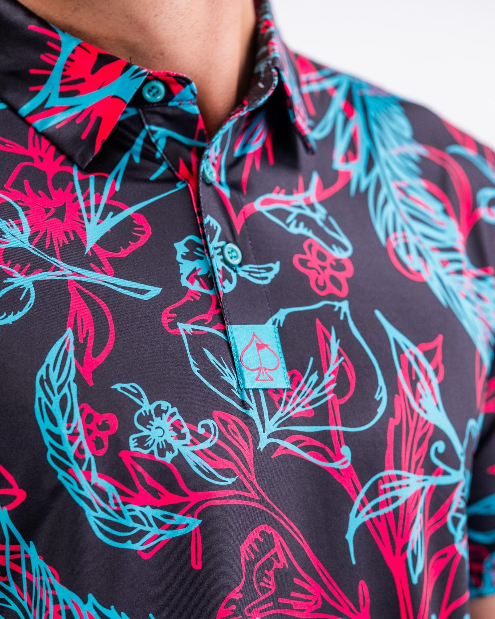 Bold floral patterned polo shirt featuring vibrant pink and blue designs, perfect for stylish golfers.