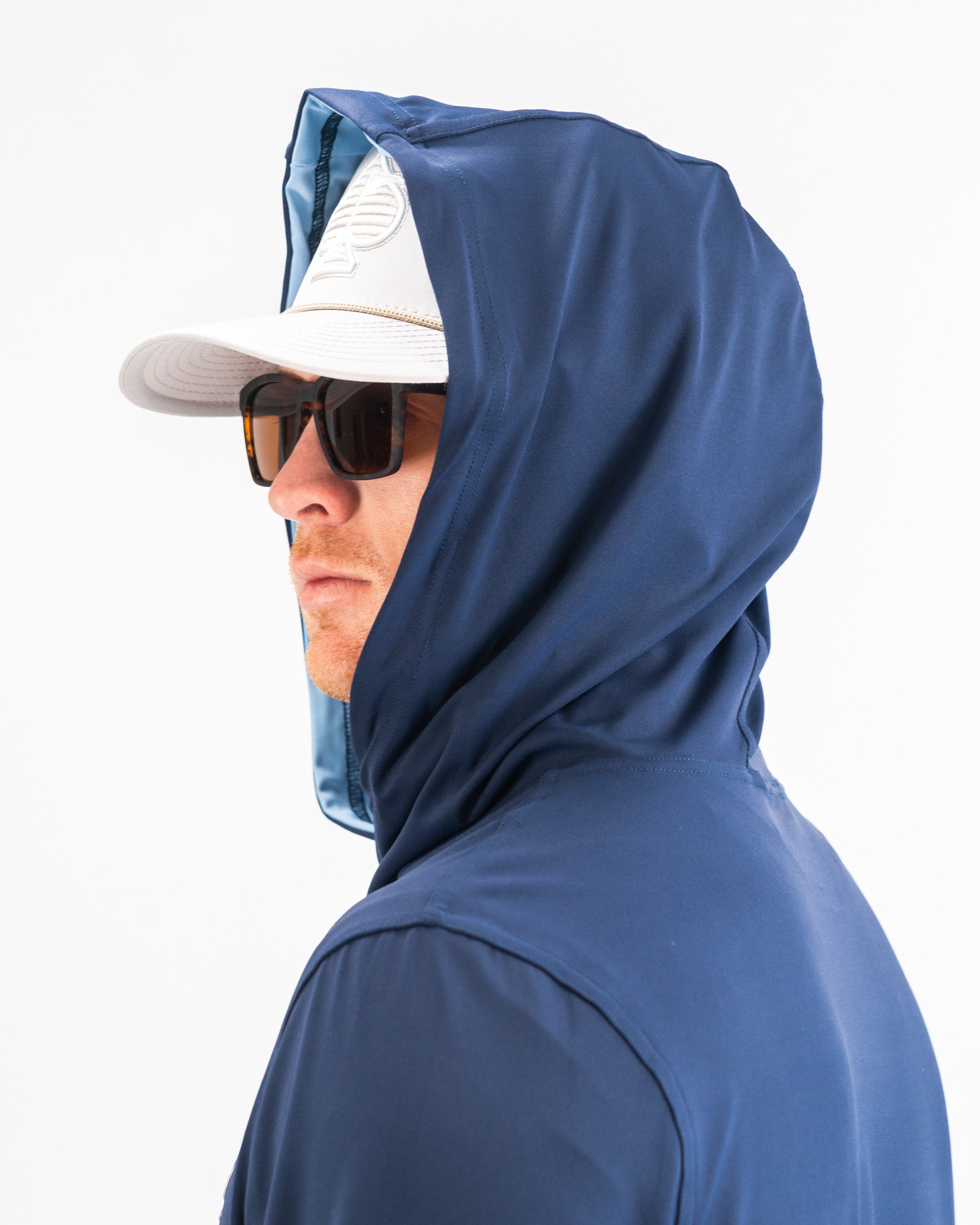 Navy performance golf hoodie featuring a fitted hood, worn by a man in sunglasses and a cap, ideal for stylish golfers.
