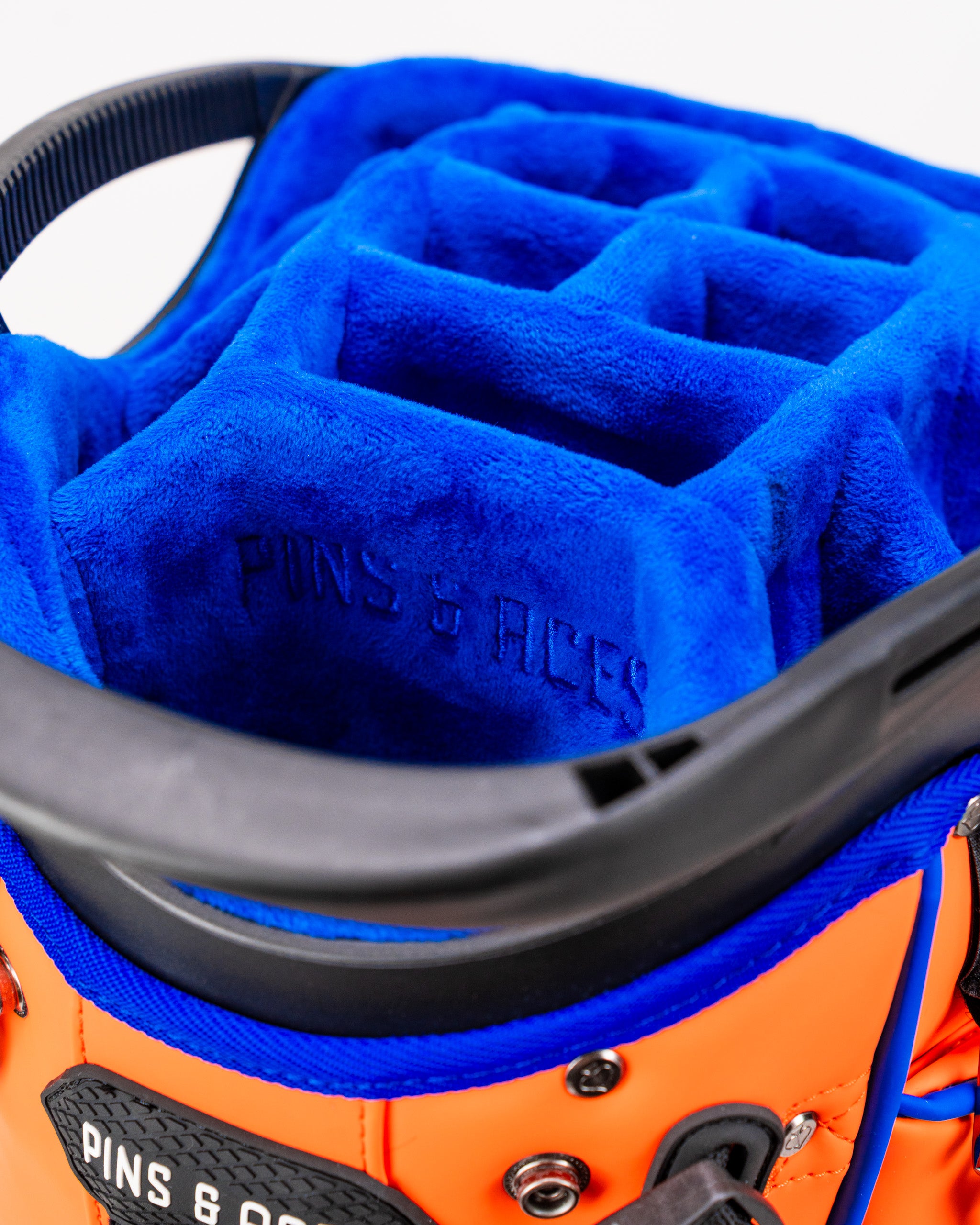 Interior view of the Player Preferred Golf Bag in Orange Crush, featuring a blue velour lining and multiple club dividers.