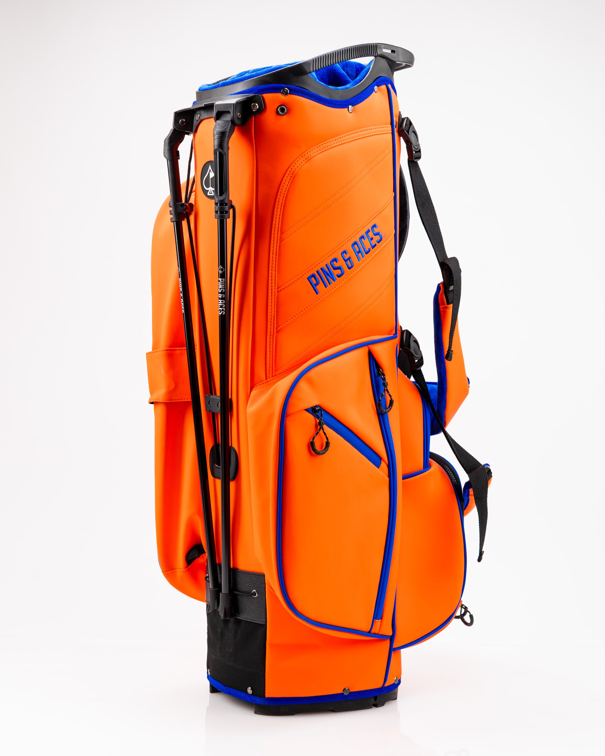 Bold orange golf bag with blue accents, featuring multiple pockets and a comfortable strap for easy carrying on the course.
