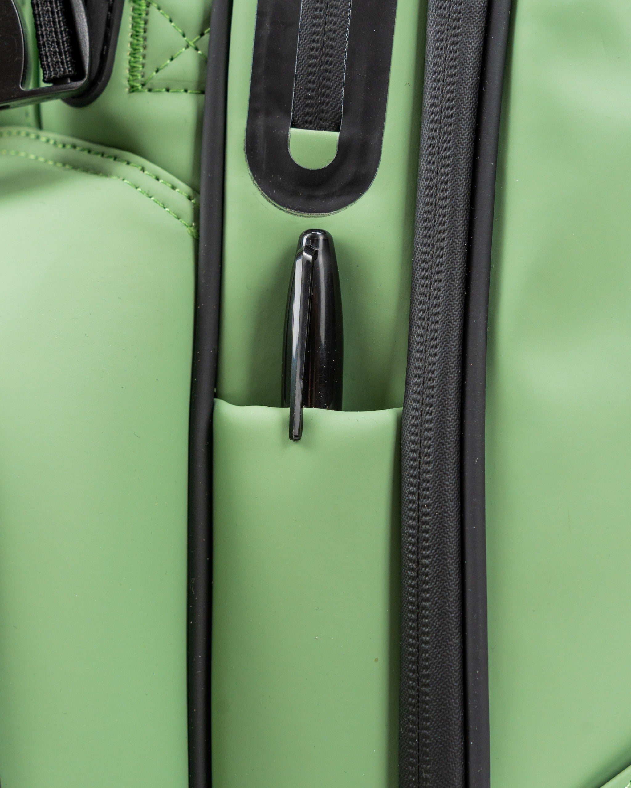Close-up of a sage green golf bag featuring a pen holder pocket, showcasing its functional design for golfers.