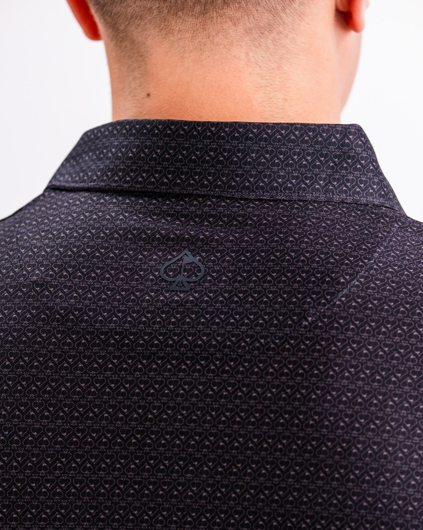 Back view of the Player Preferred Polo in Midnight Spade, featuring a subtle spade pattern and logo detail.