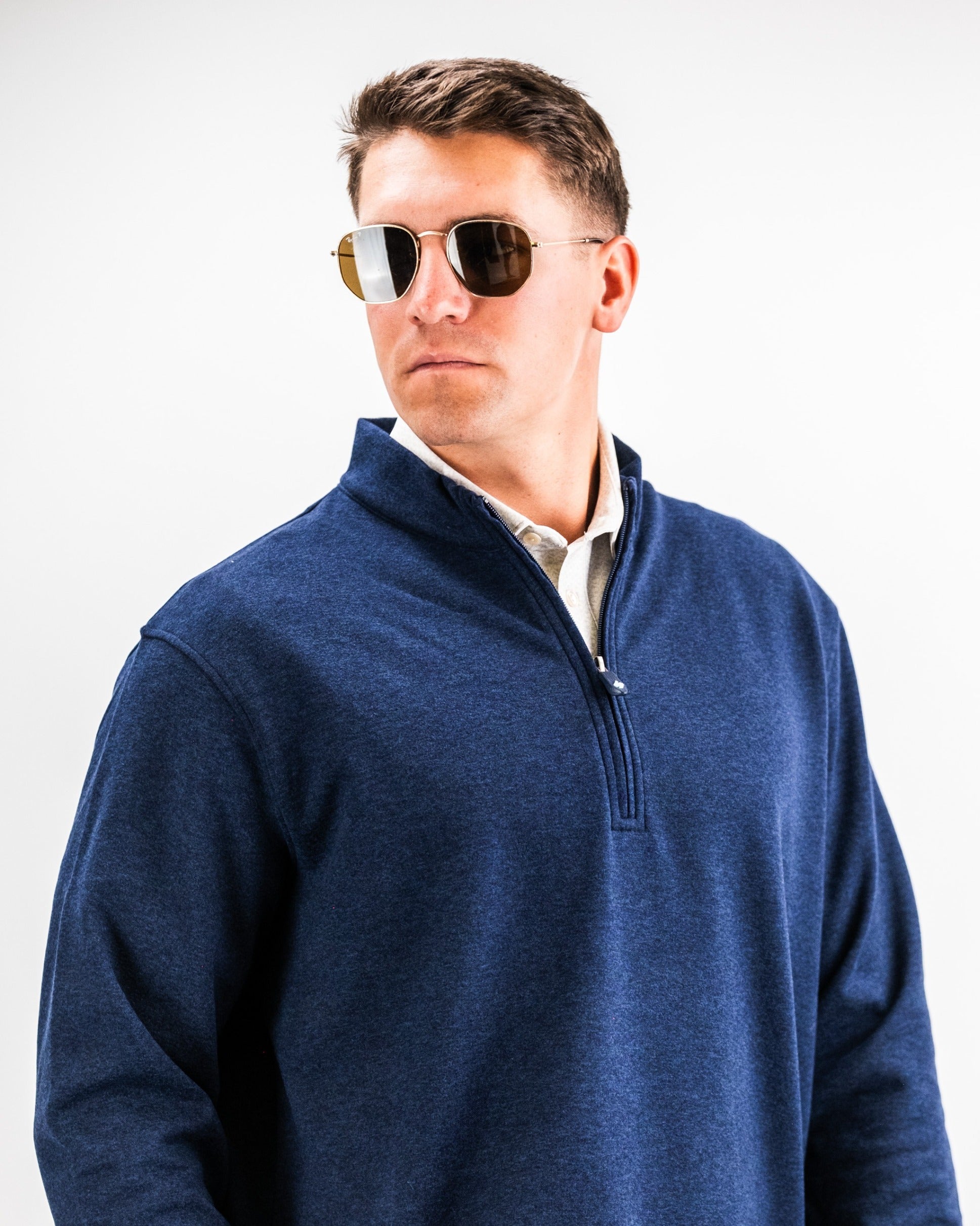 Stylish man wearing a heathered navy Player Preferred pullover with sunglasses, showcasing a modern golf look.