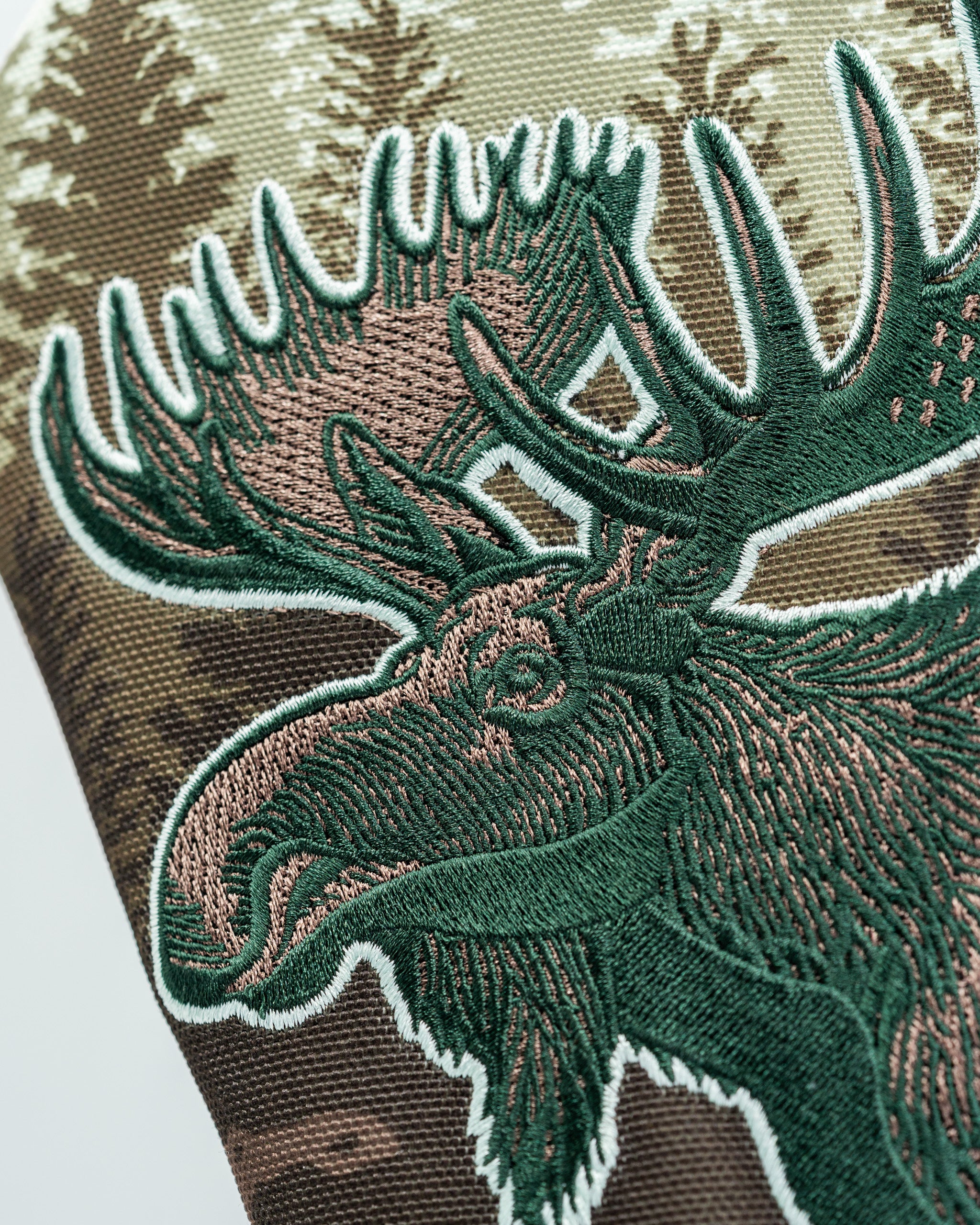 Embroidered moose design on a driver cover featuring a camouflage background, perfect for unique golf style.