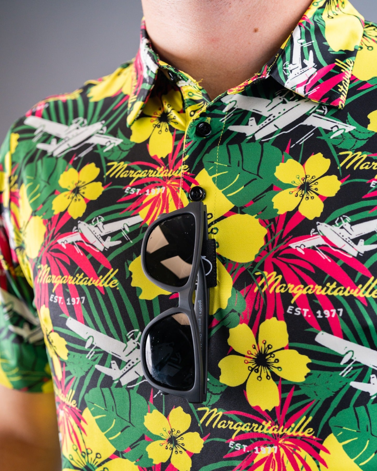 Vibrant Margaritaville Daydreamin' shirt featuring tropical flowers and palm leaves, paired with stylish sunglasses.