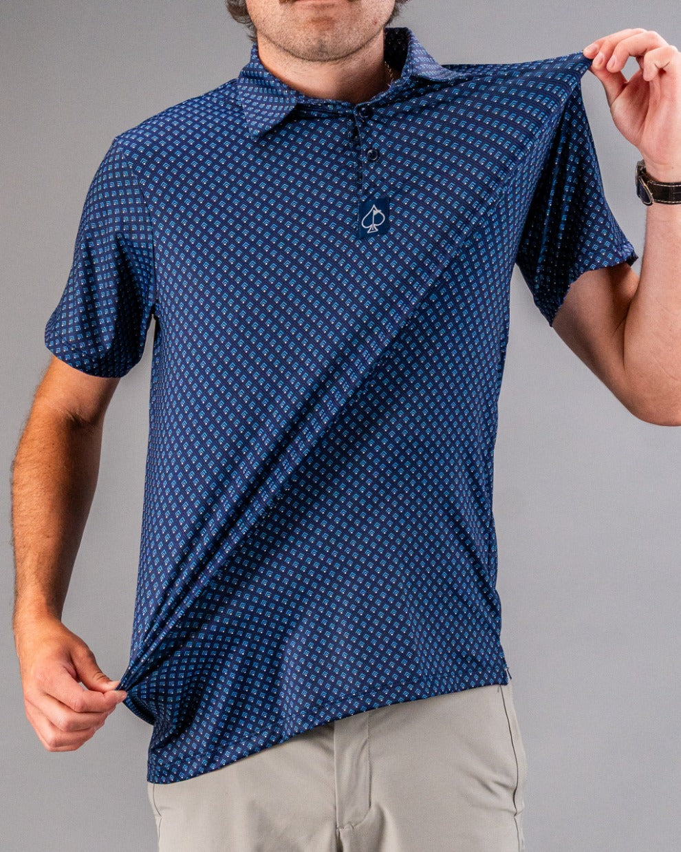 Blue golf polo with small geometric pattern, classic collar, and a bold golf logo on the chest, perfect for standing out o...