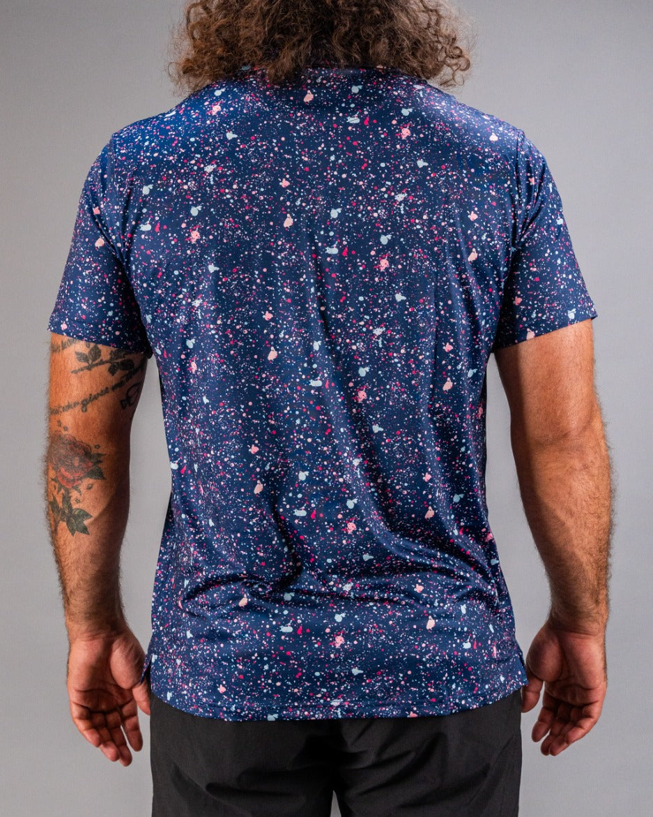Men's blue splatter golf shirt featuring a vibrant, colorful pattern, perfect for standing out on the course.