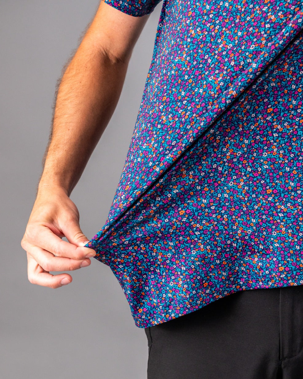 Men's golf shirt featuring a vibrant lavender floral pattern, showcasing a close-up of the fabric and fit.