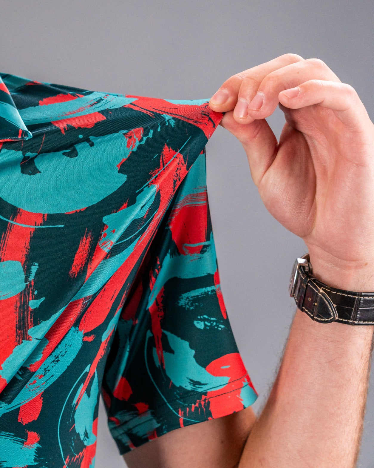 Bold golf shirt featuring a vibrant coral and teal paint stroke design, perfect for making a statement on the course.