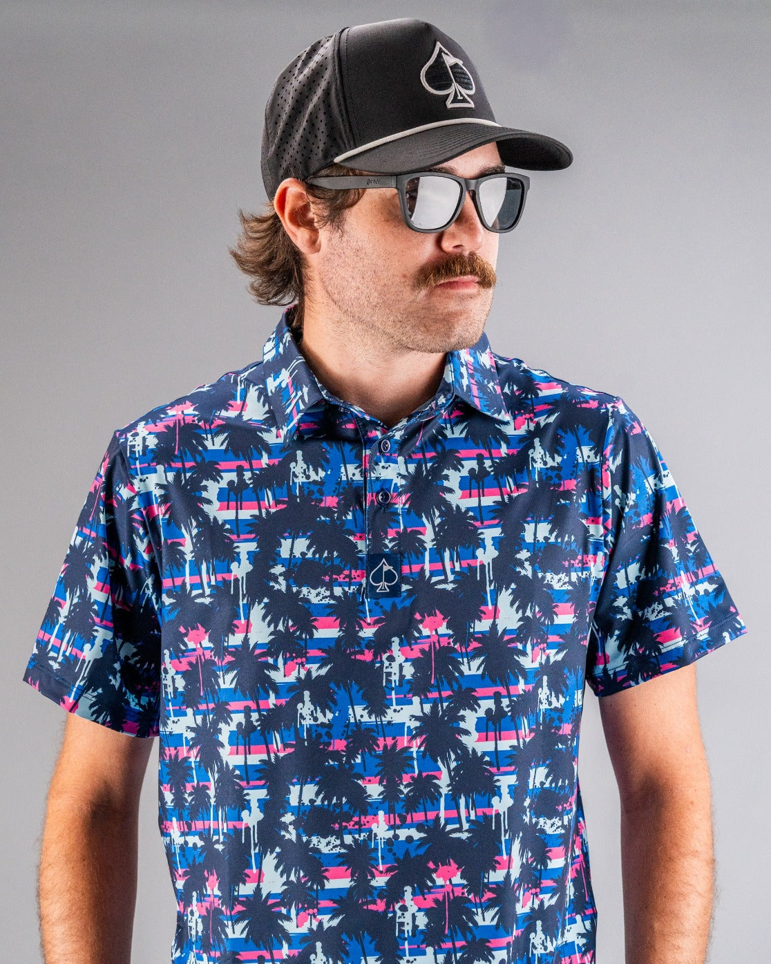 Bold golf polo featuring a vibrant palm tree and sunset design, perfect for stylish golfers on the course.