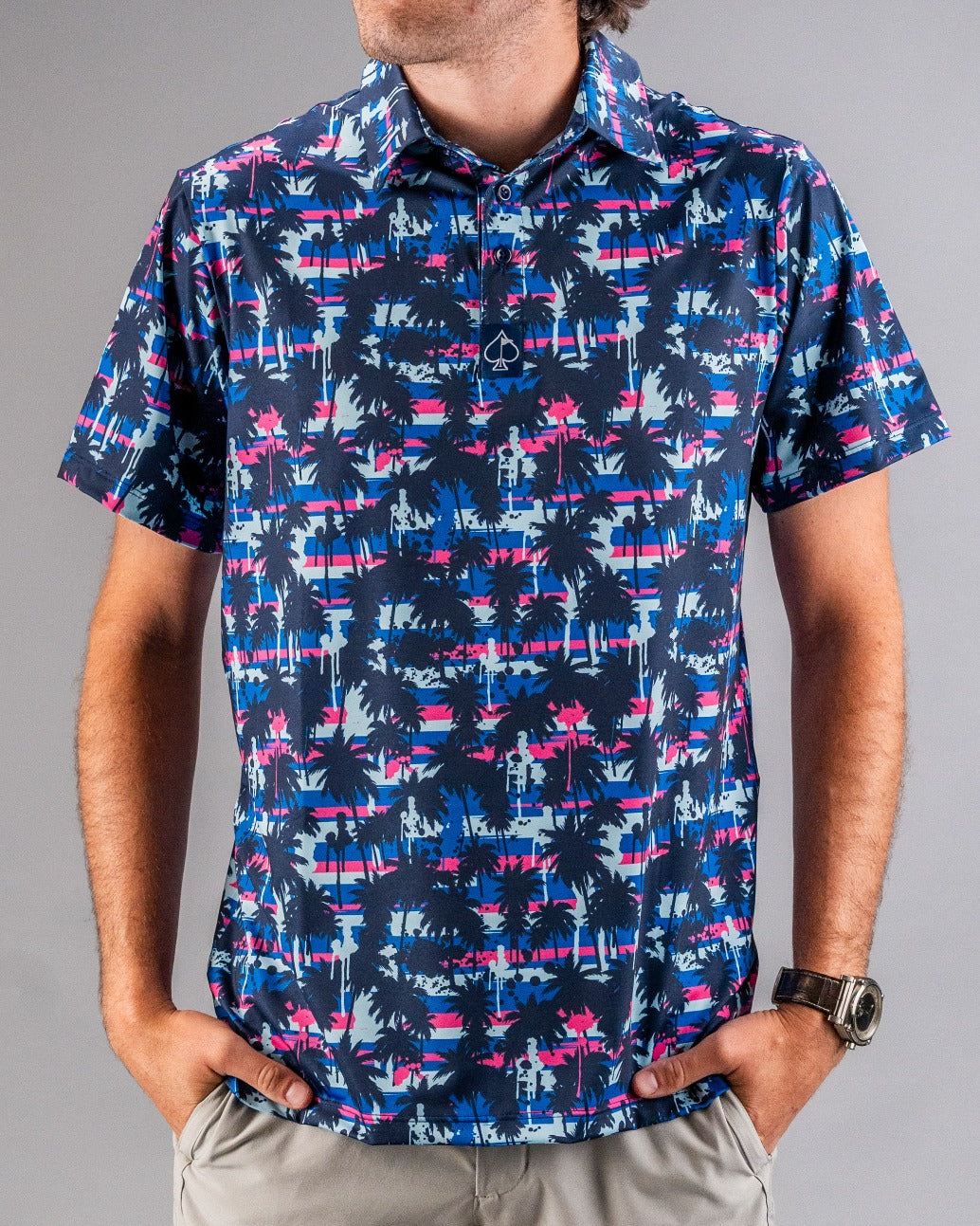 Men's short-sleeve golf shirt featuring a vibrant palm tree and sunset pattern in blue, pink, and purple hues.