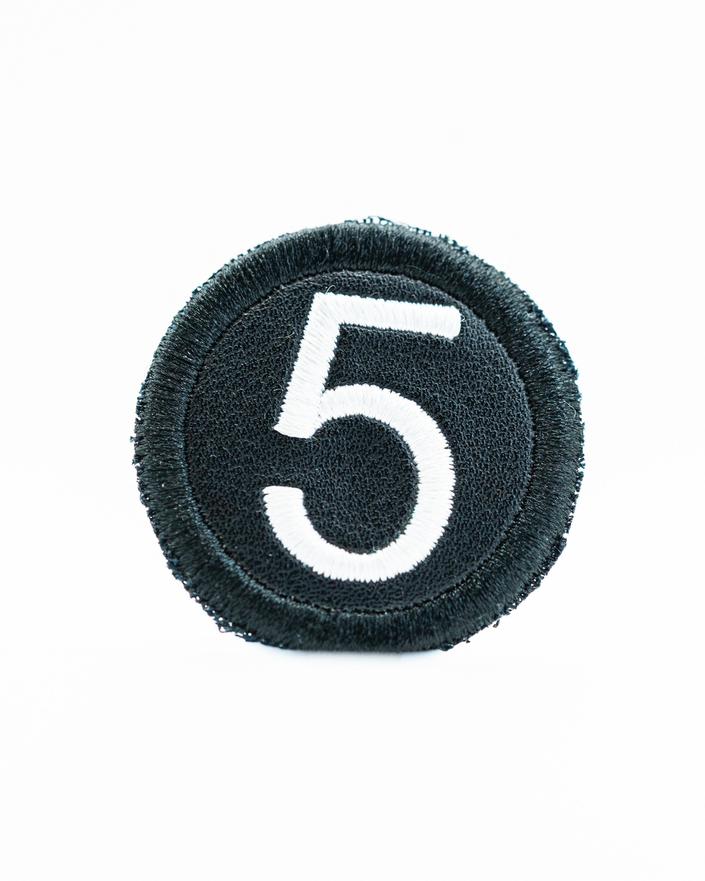 Black headcover patch featuring a large white number five, designed for golfers to personalize their gear.