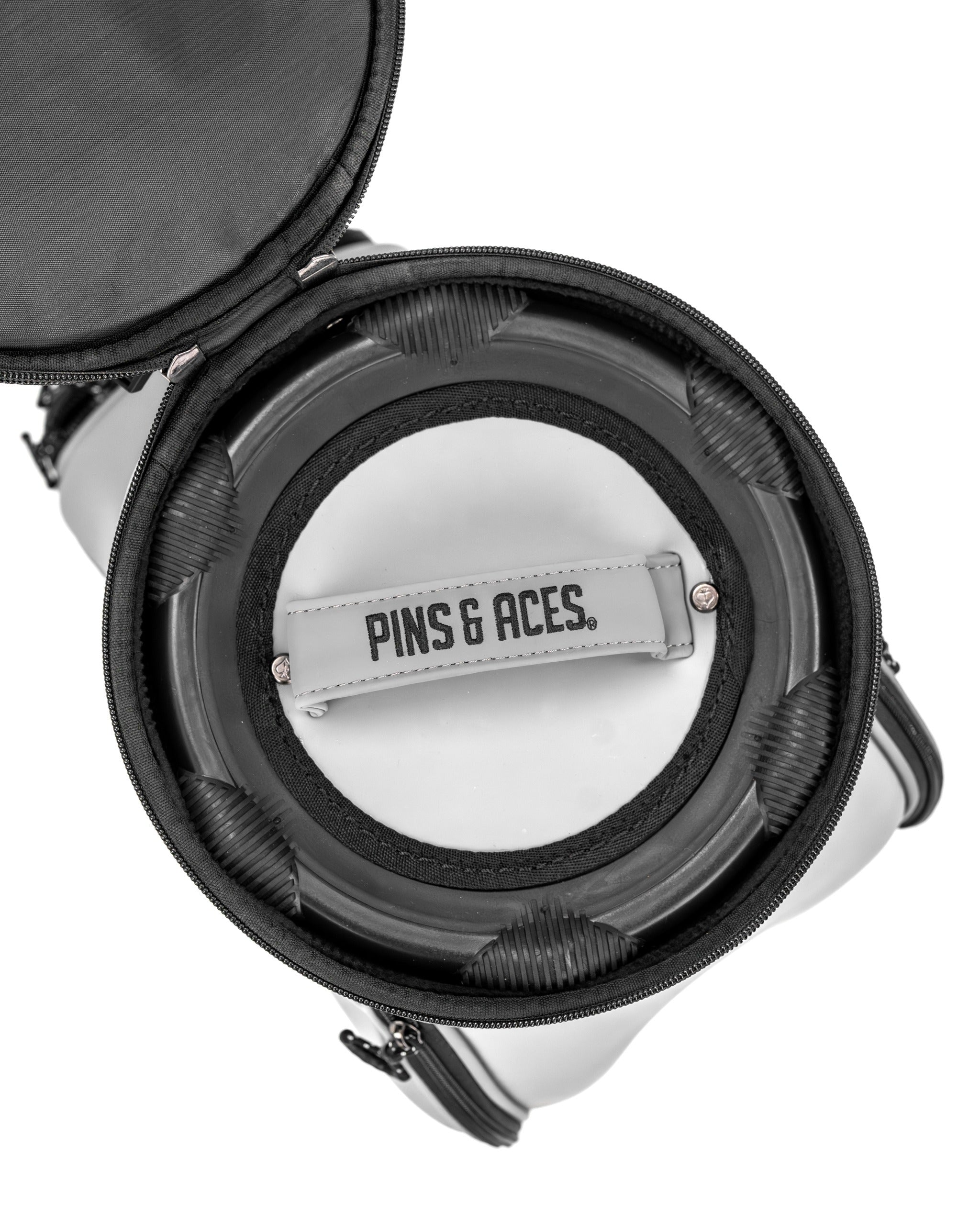 Inside view of the Den Caddy - Flat Ash, showcasing a circular design with a branded tag and padded compartments.