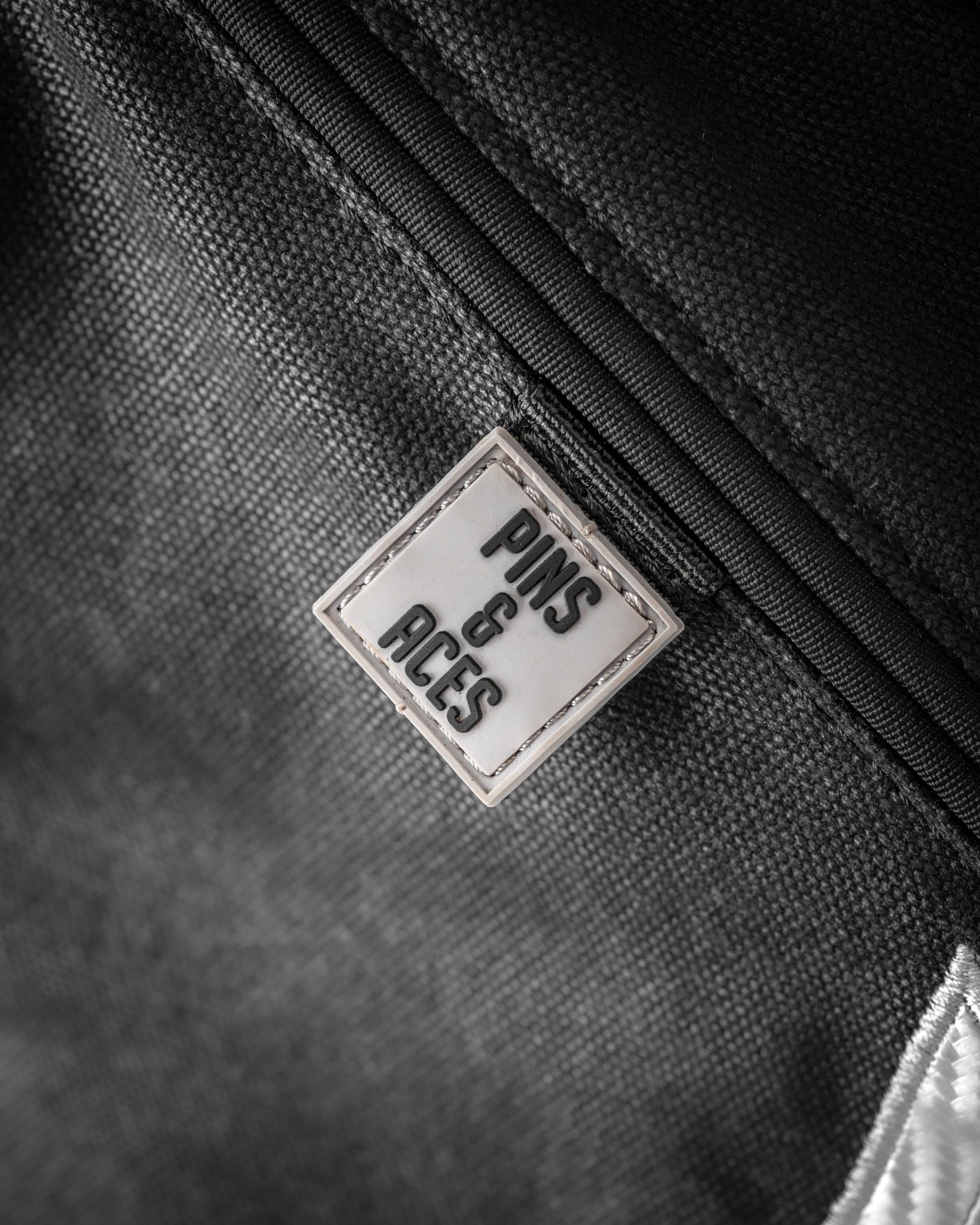 Stylish Sunday golf bag featuring a sleek design and the Pins and Aces logo, perfect for golfers on the go.