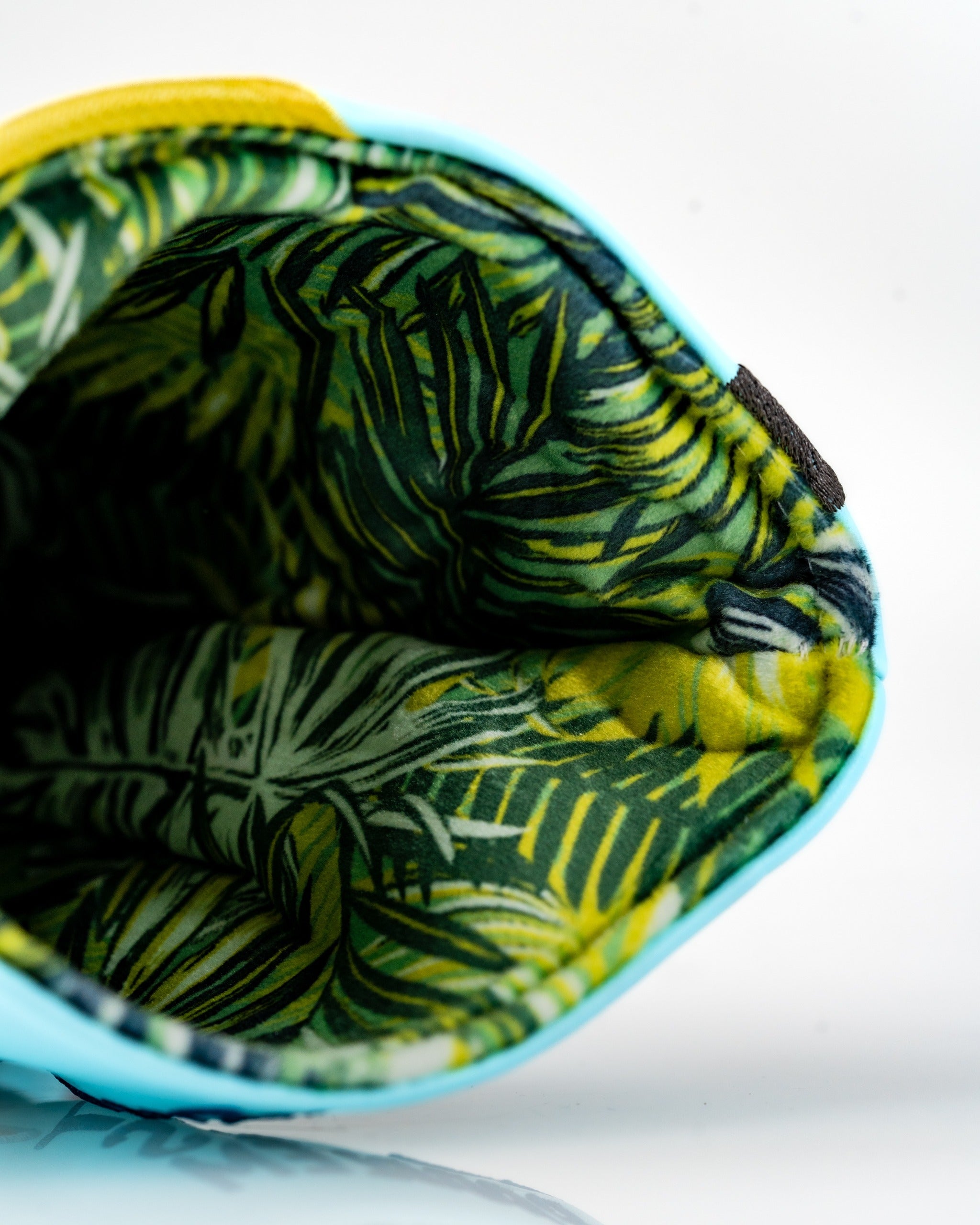Bright blue driver cover featuring a vibrant tropical leaf interior, perfect for adding style to your golf game.