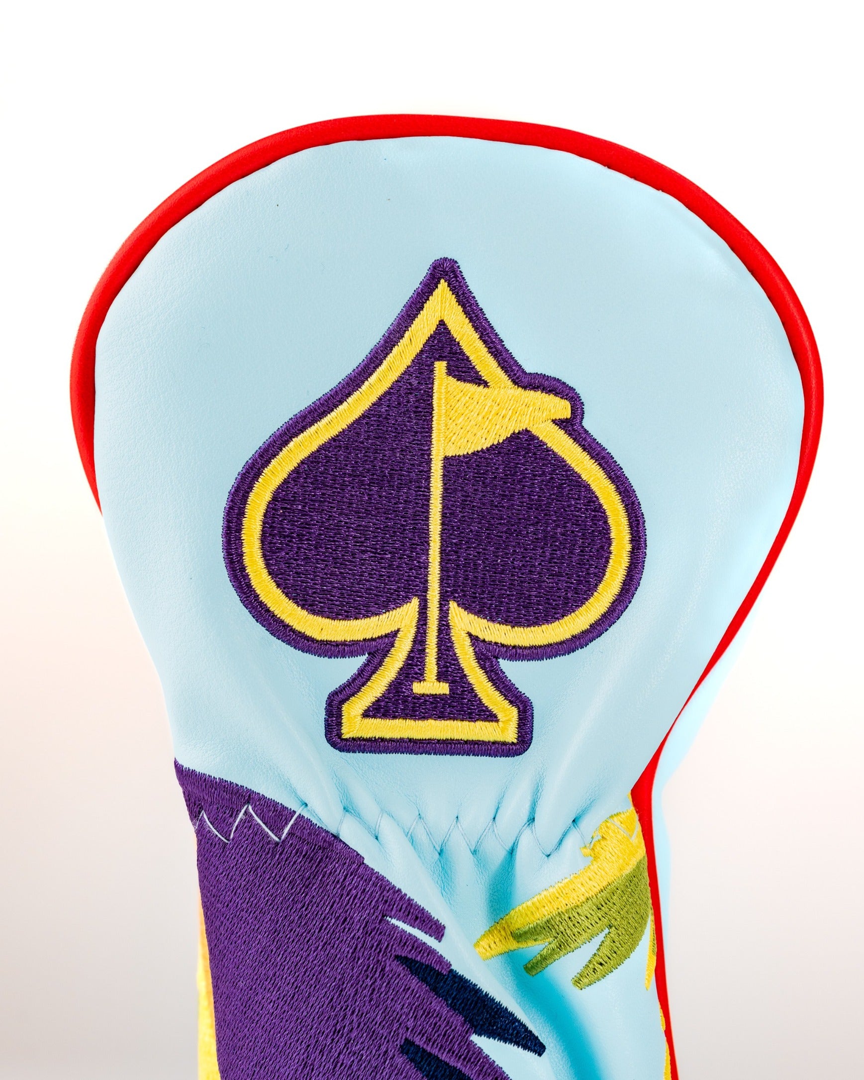 Colorful golf headcover featuring a vibrant parrot design and a spade emblem, perfect for adding flair on the course.