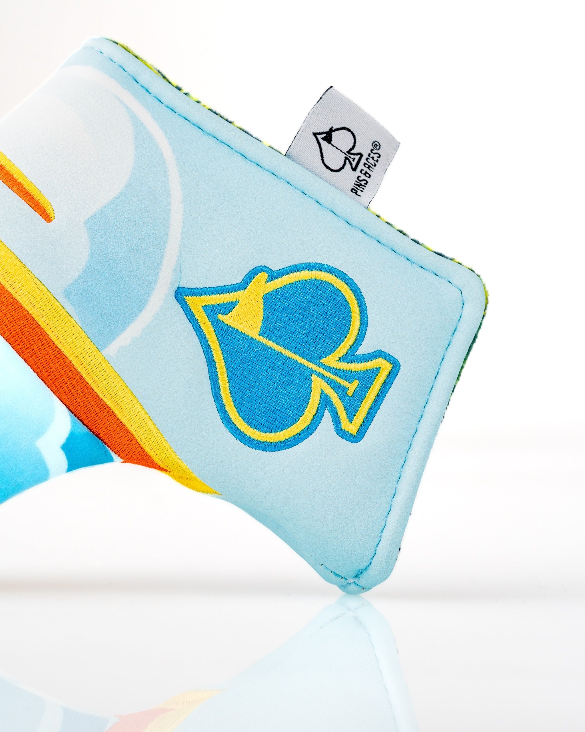 Brightly colored Margaritaville Puddle Jumper blade putter cover featuring a playful spade design and cloud patterns.