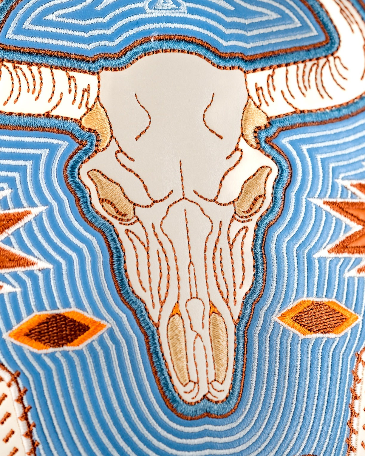 Western aesthetic driver cover featuring a detailed embroidered bull skull design on a vibrant blue background.