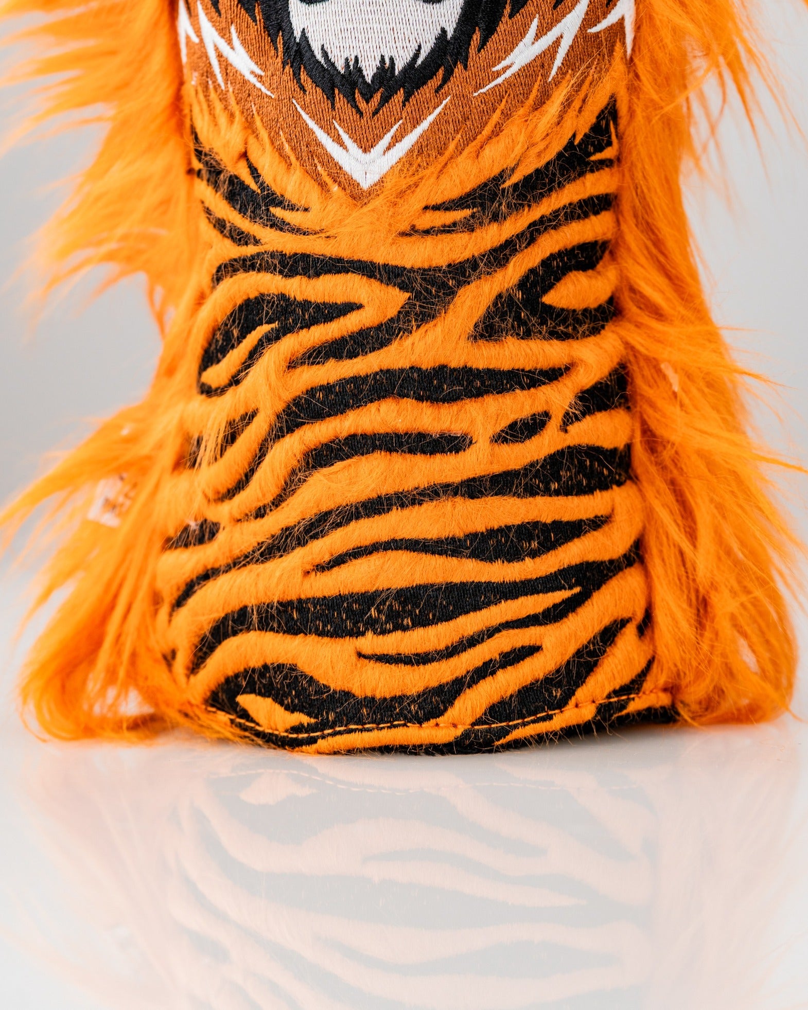 Bold orange tiger driver cover with black stripes and a fierce face, perfect for golfers wanting to stand out on the course.
