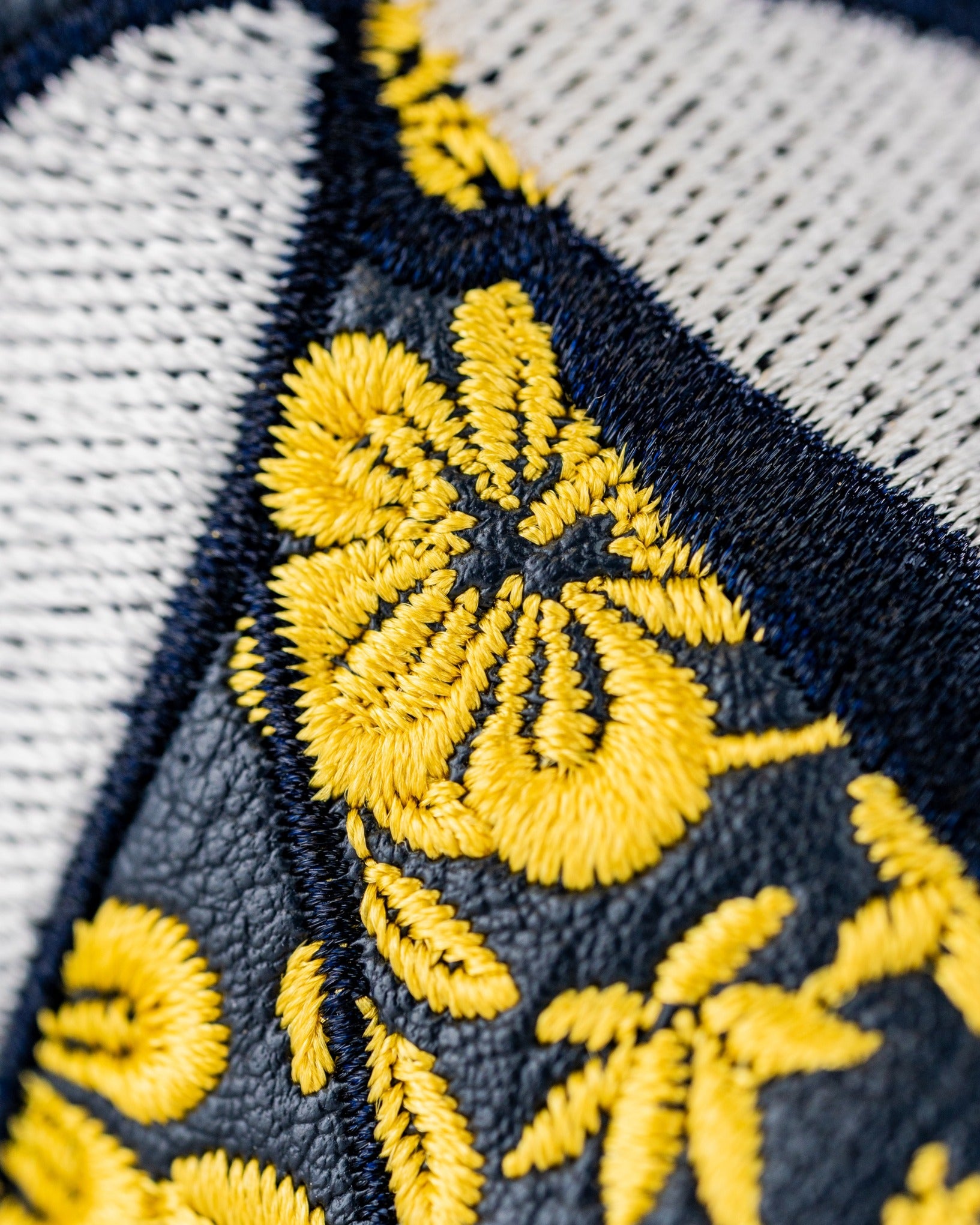 Embroidered floral design in yellow and navy on a golf blade cover, showcasing a bold and unique style for golfers.