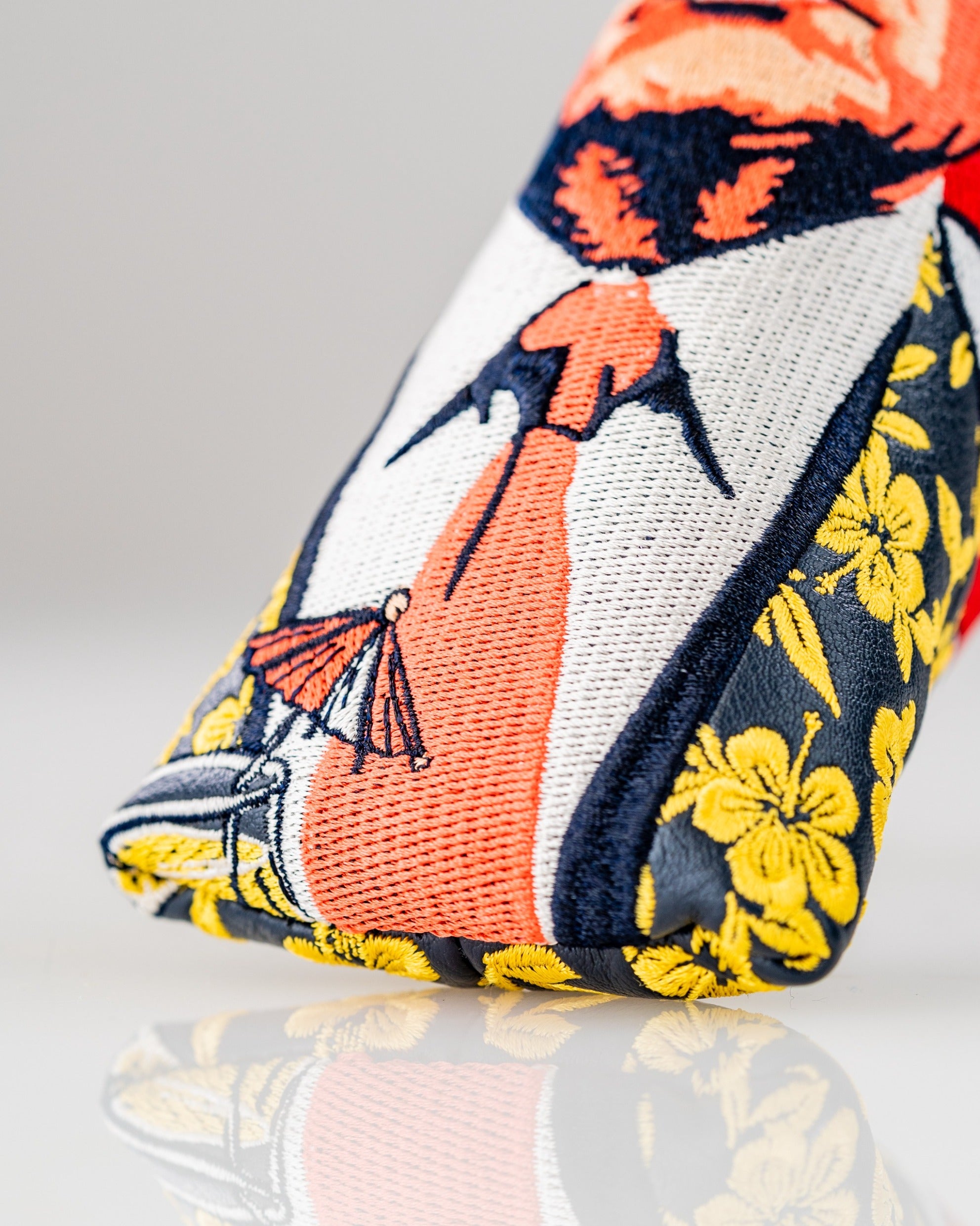 Bold golf blade cover featuring vibrant embroidery of a character with floral accents, perfect for unique style on the course.